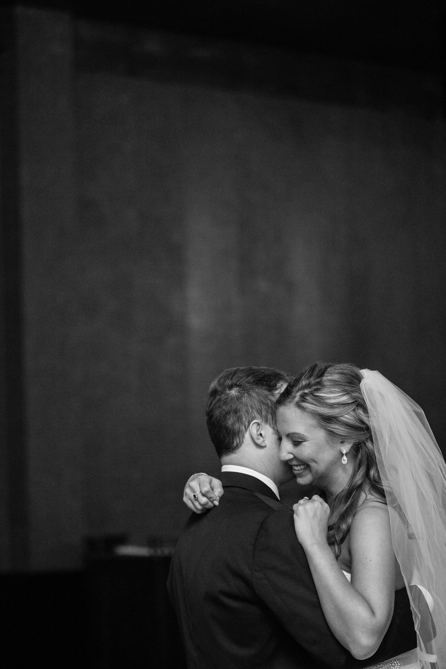 A tender black and white wedding moment captured as newlyweds share an intimate embrace on their special day.