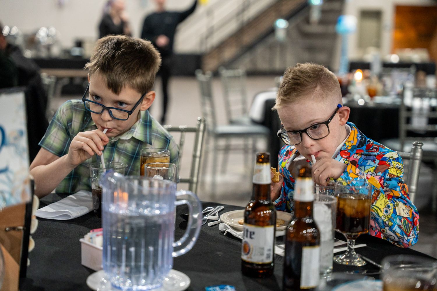 two boys drinking from straws