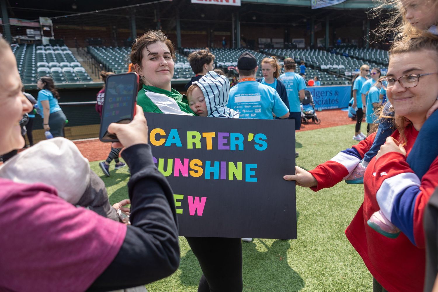 A colorful sign reading Carter's Sunshine Crew is displayed during an outdoor event.