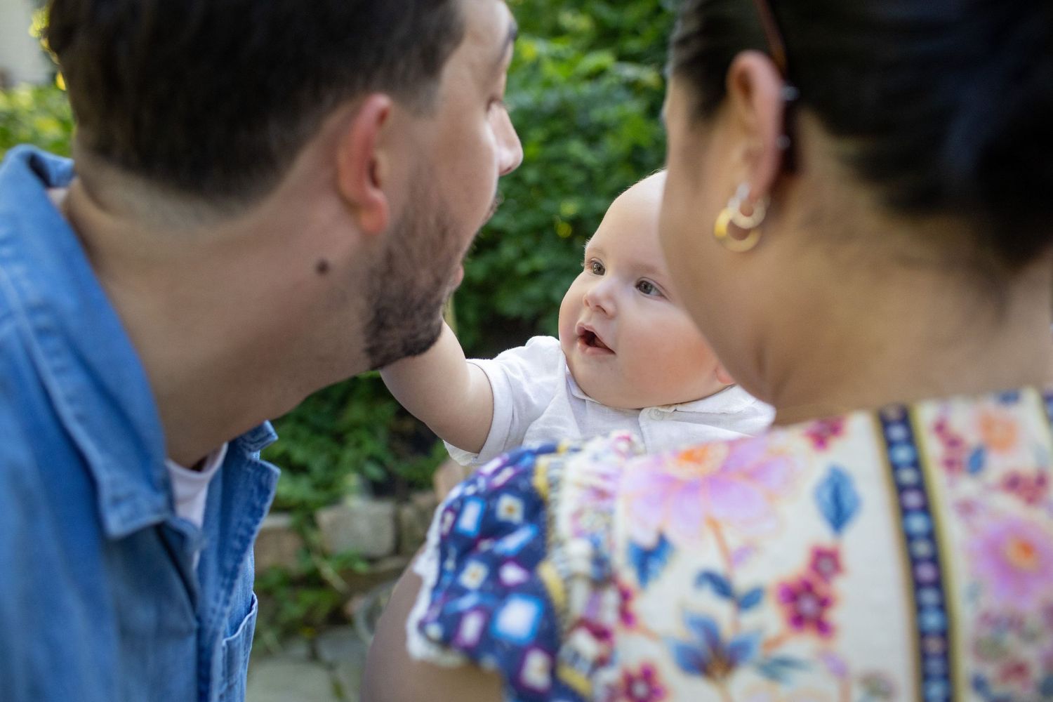 People in floral and denim clothing sharing intimate moments at an outdoor gathering.