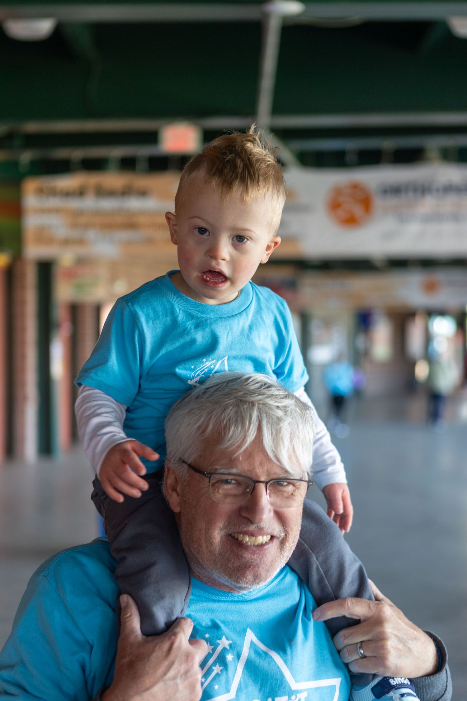 A heartwarming moment shared between family members wearing matching light blue shirts indoors.