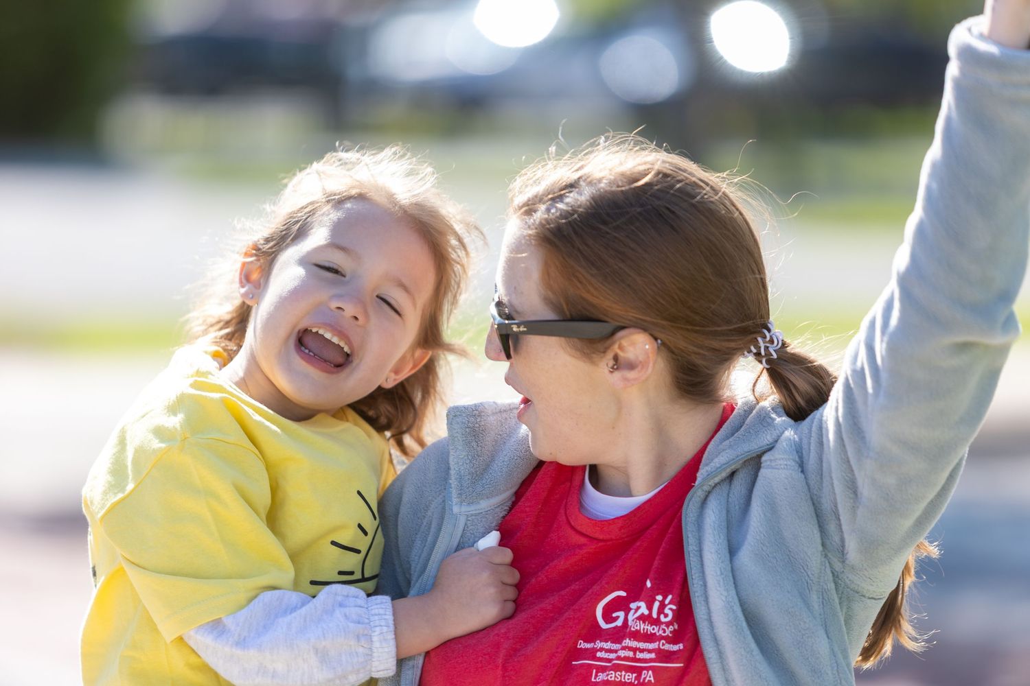 Two participants sharing joyful moment during outdoor community event.