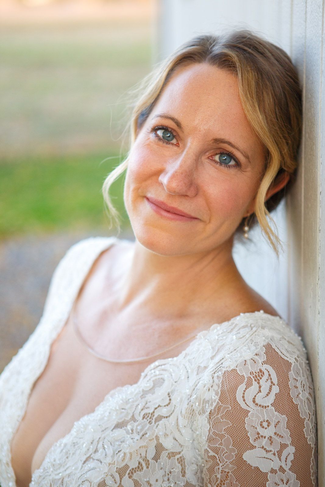 smiling bride by a white wall