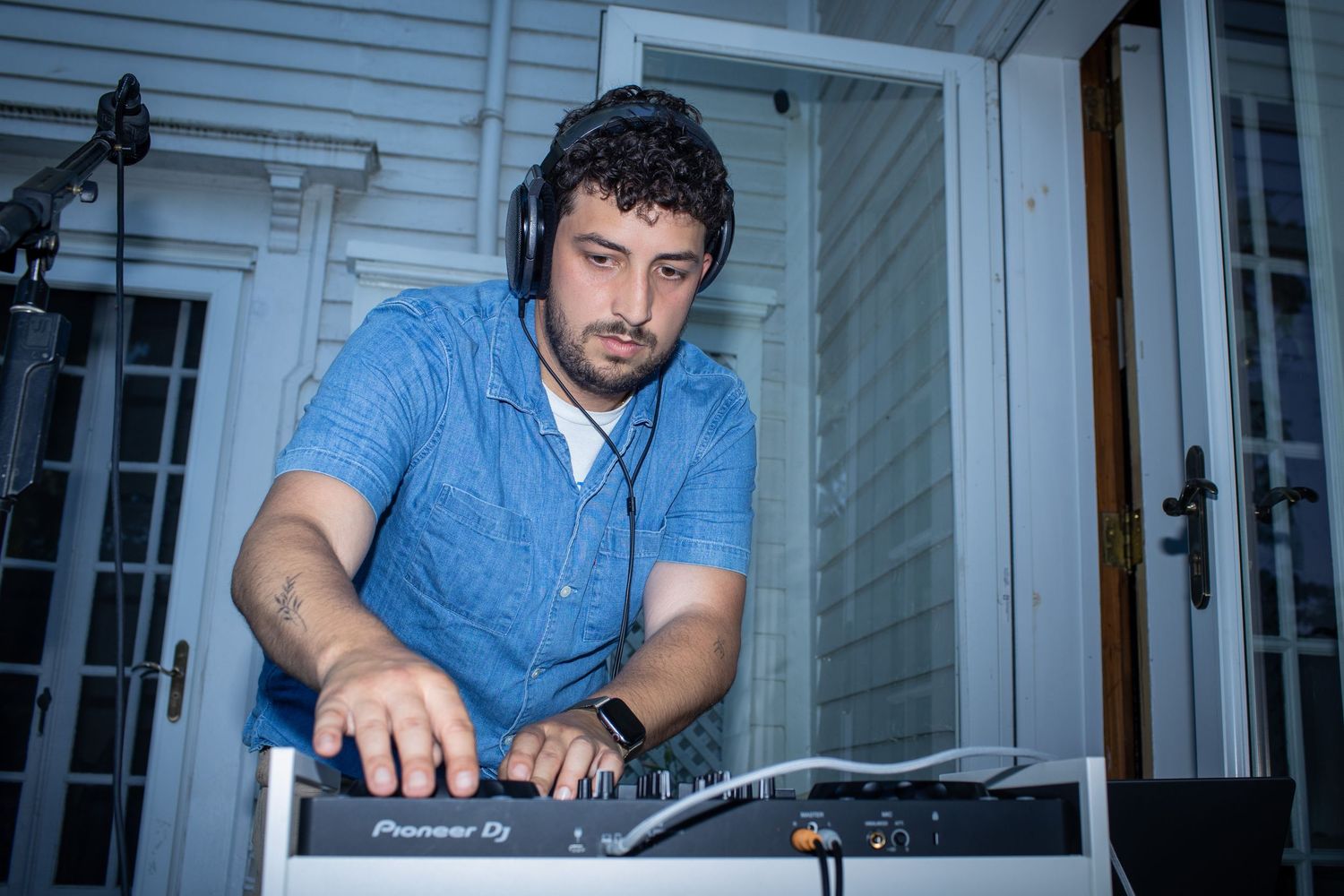 Vintage photo collection shows DJ mixing music on turntables in blue room from different angles.