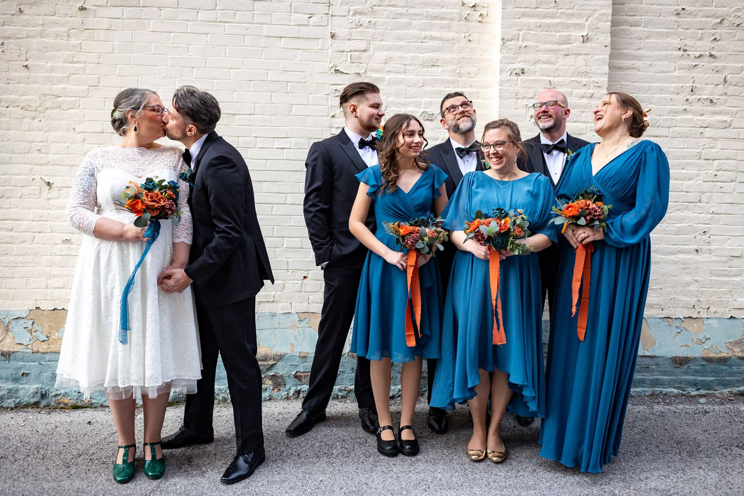 wedding party and bride and groom in an alley