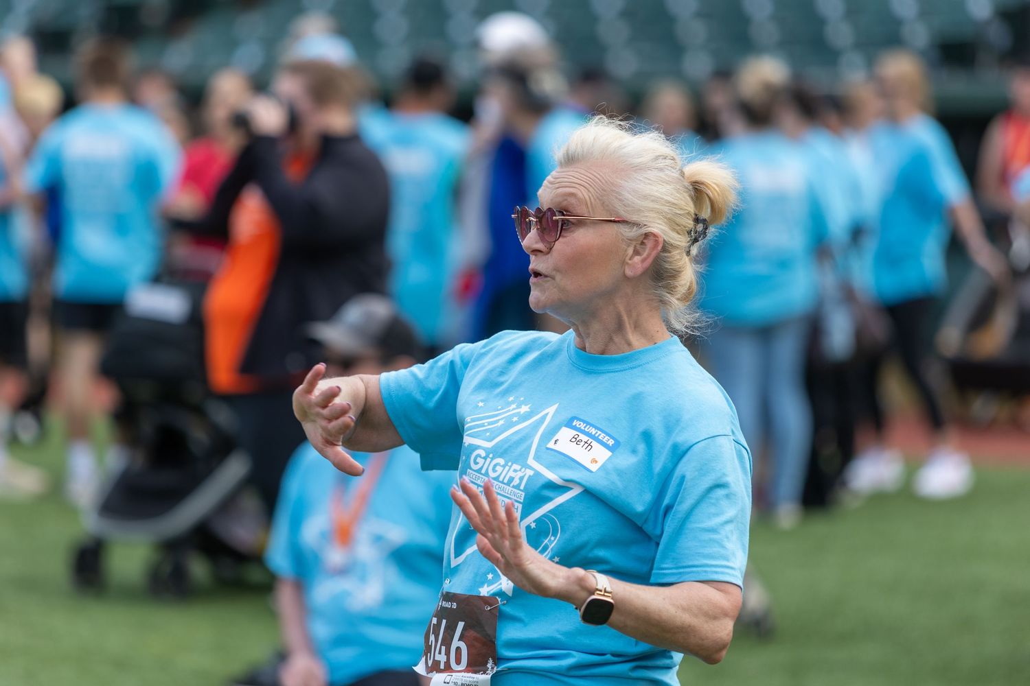 Person in light blue t-shirt participating in outdoor sporting event at stadium.