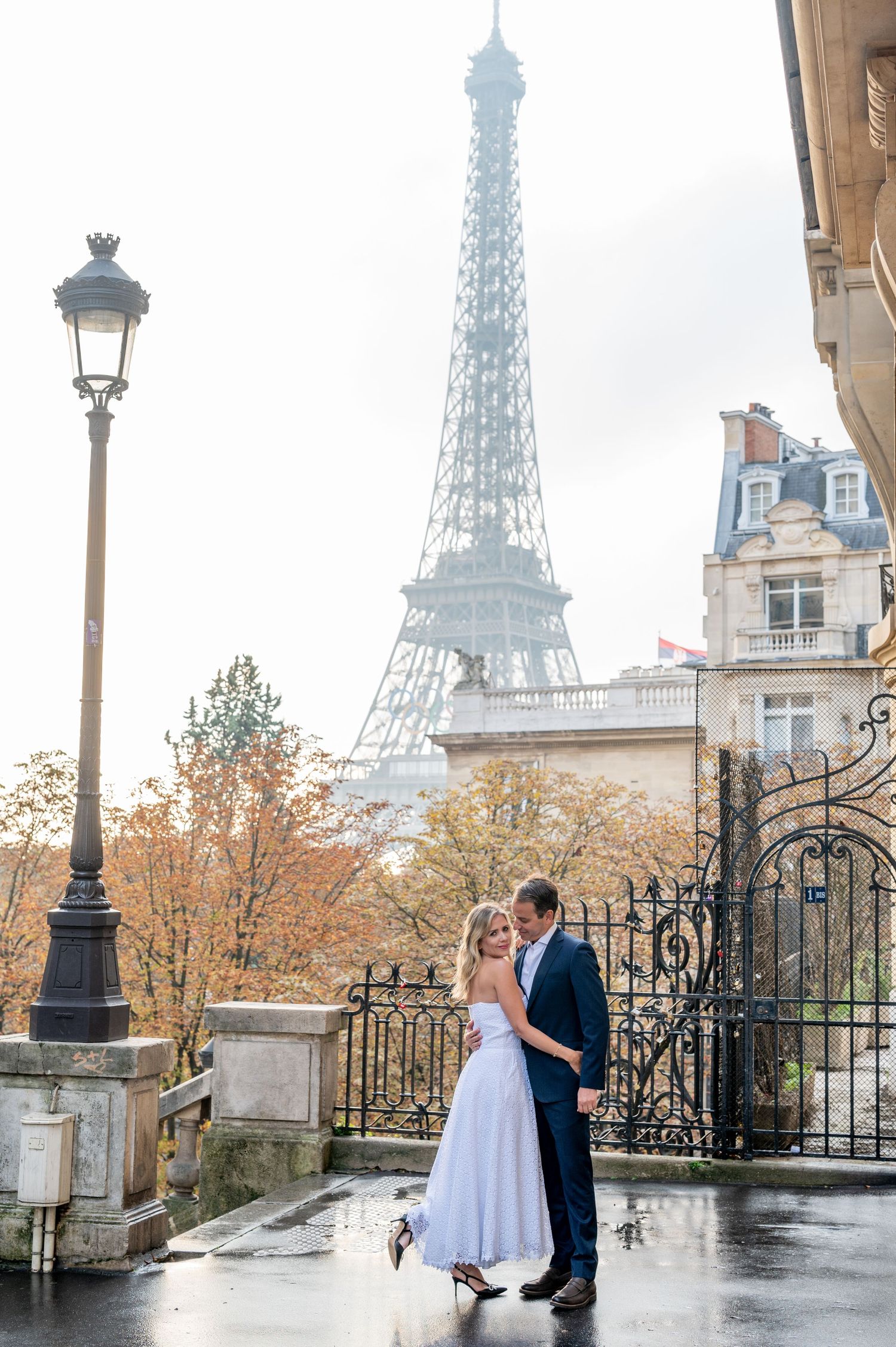A romantic moment captured near the Eiffel Tower on a rainy Paris day.