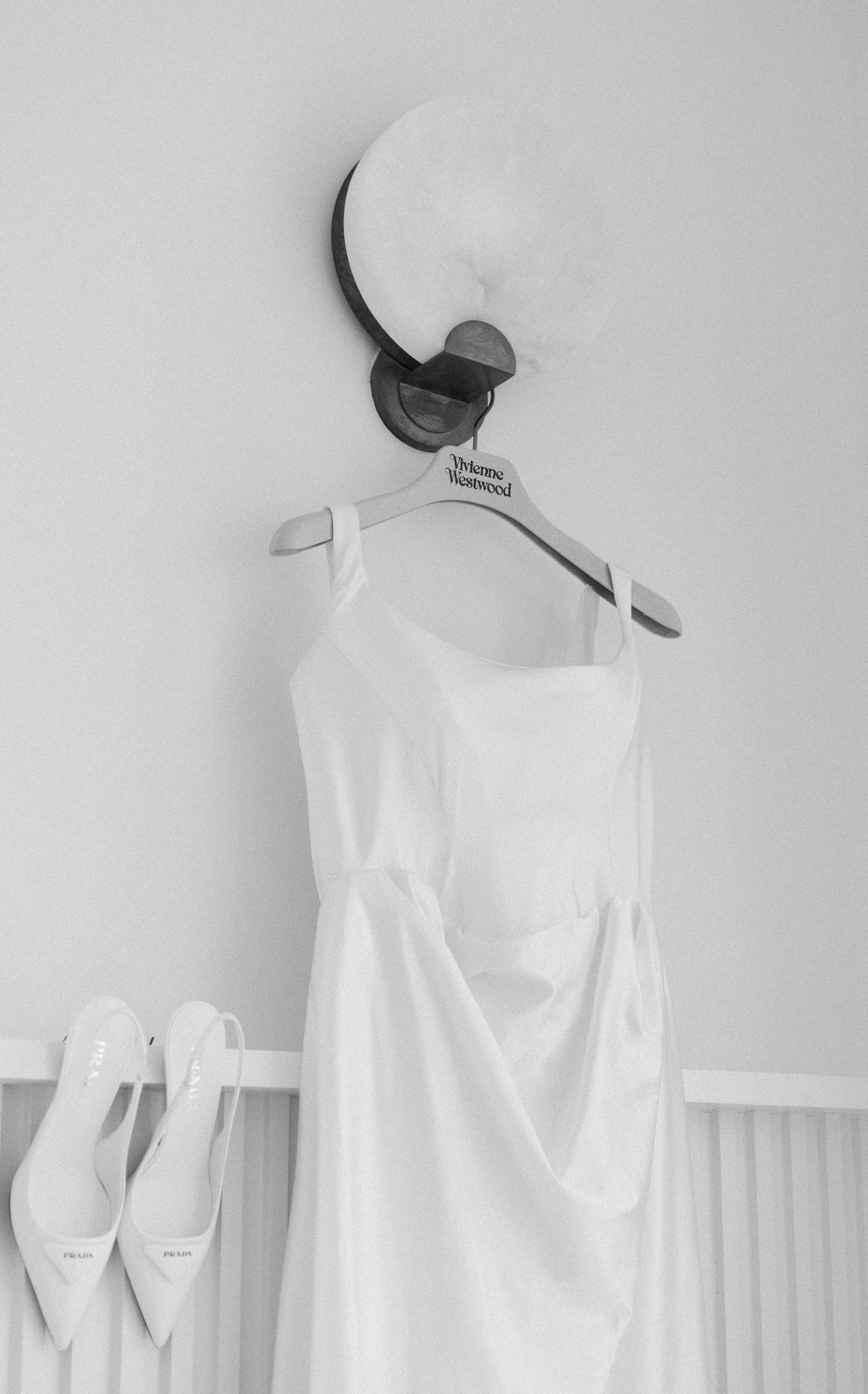 Row of elegant white bridesmaid dresses hanging on display against a light gray wall.