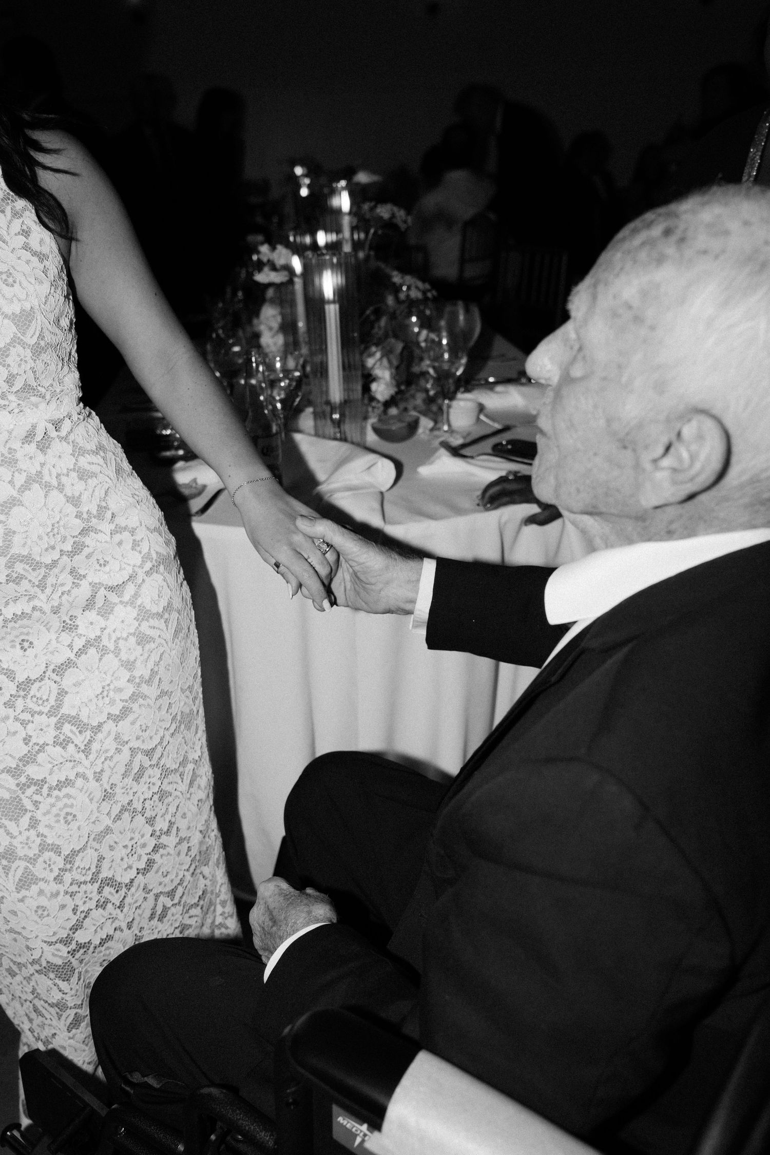 Black and white photos show someone being helped with dining and feeding assistance at an elegant restaurant table setting.