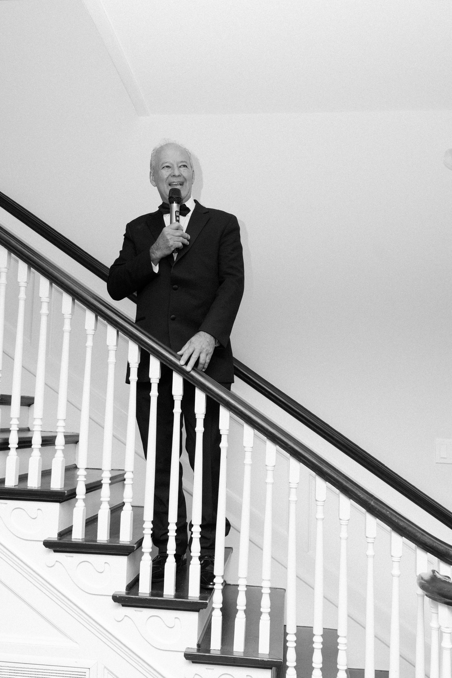 A sequence of playful poses descending a white staircase with dark railings.