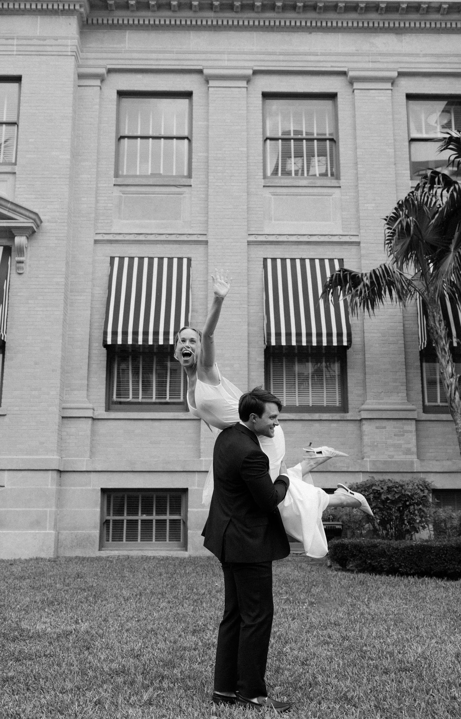 Black and white photos show someone letting doves fly out of four windows in sequence at a historic stone building.