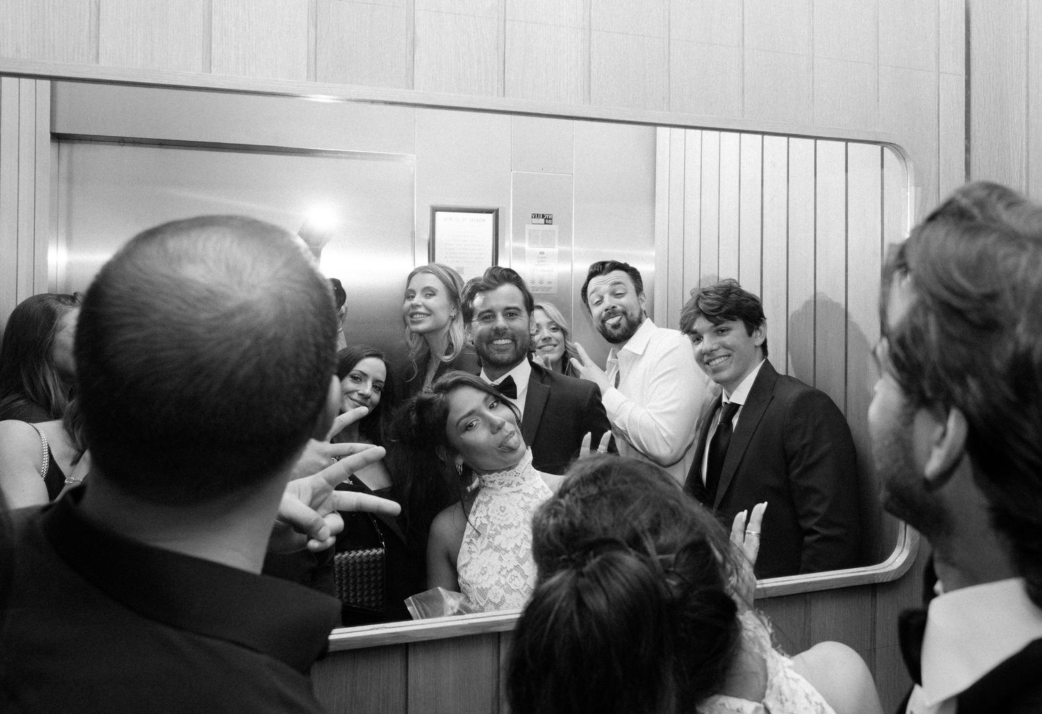 Black and white panoramic of wedding guests gathered in a reception hall.