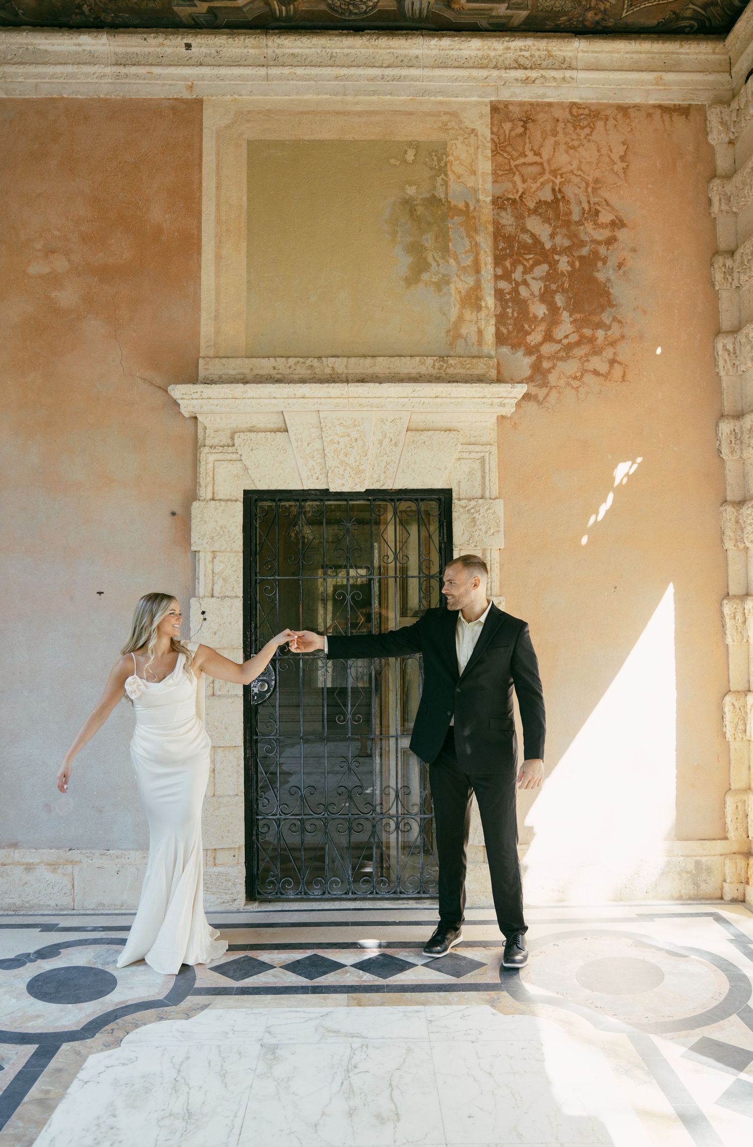 Wedding couple dancing in sequence against weathered wall with dramatic lighting and shadows.