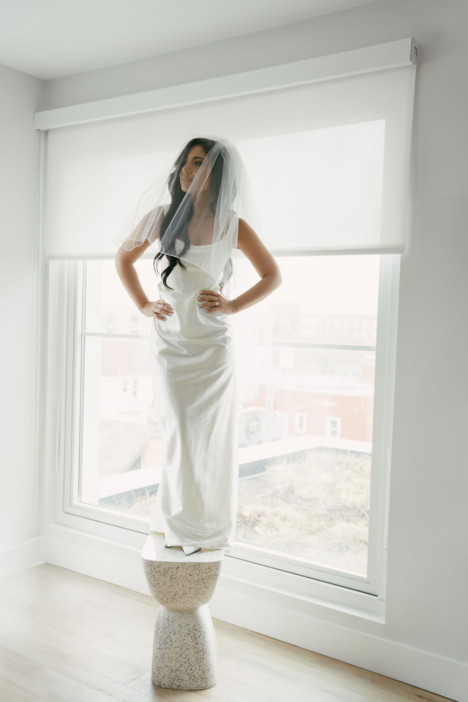 A composite photo series shows someone in a white dress posing near bright windows in a minimalist setting.