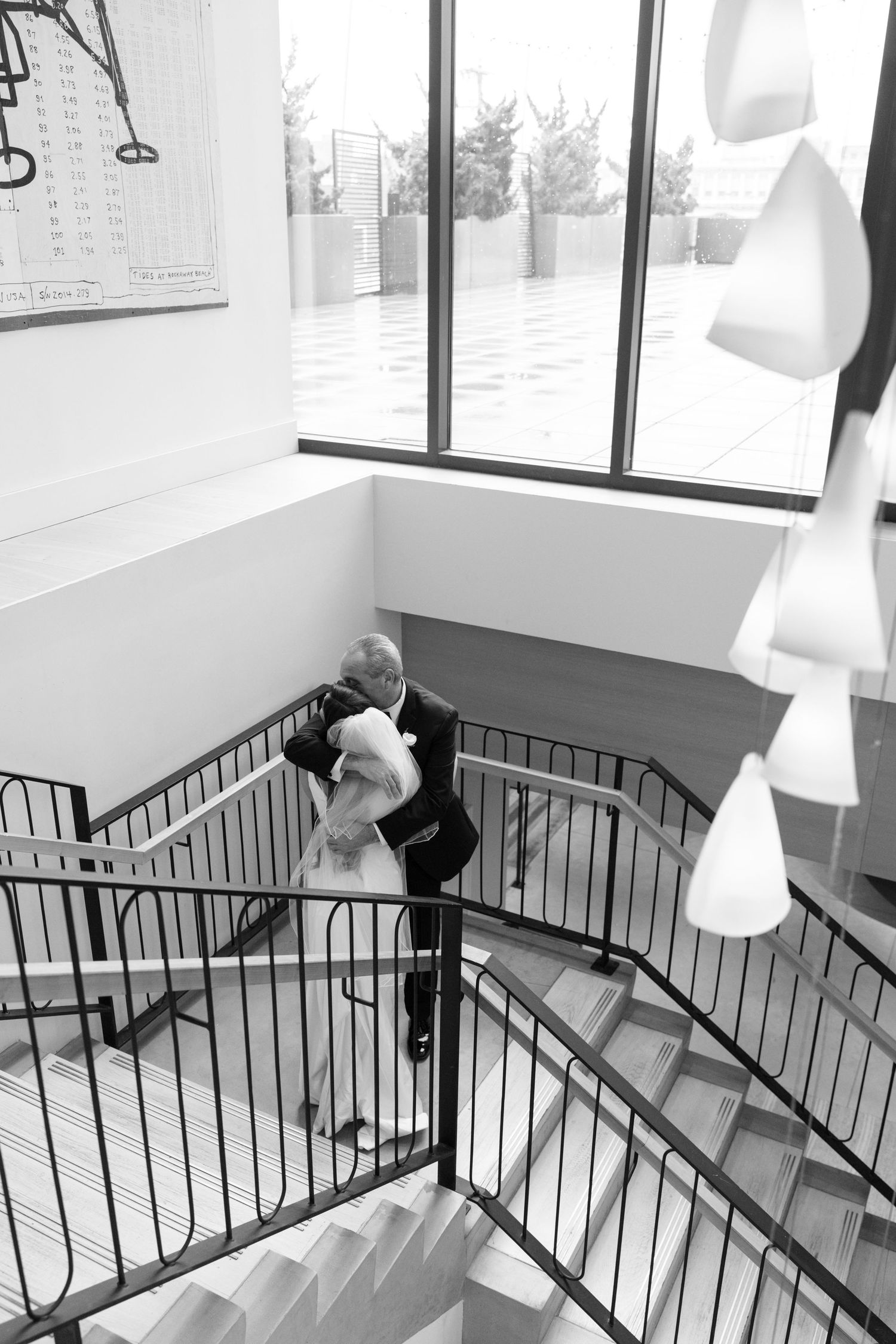 Black and white series showing a bride walking across railings in an indoor space.