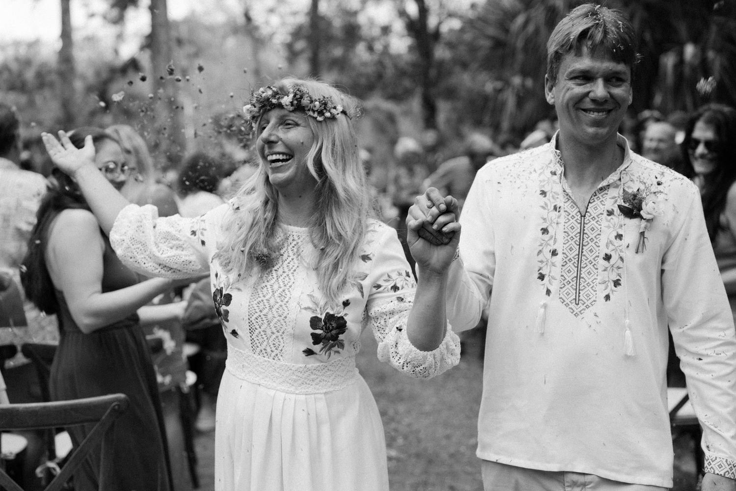 A joyful wedding celebration in an outdoor garden setting with confetti being thrown.
