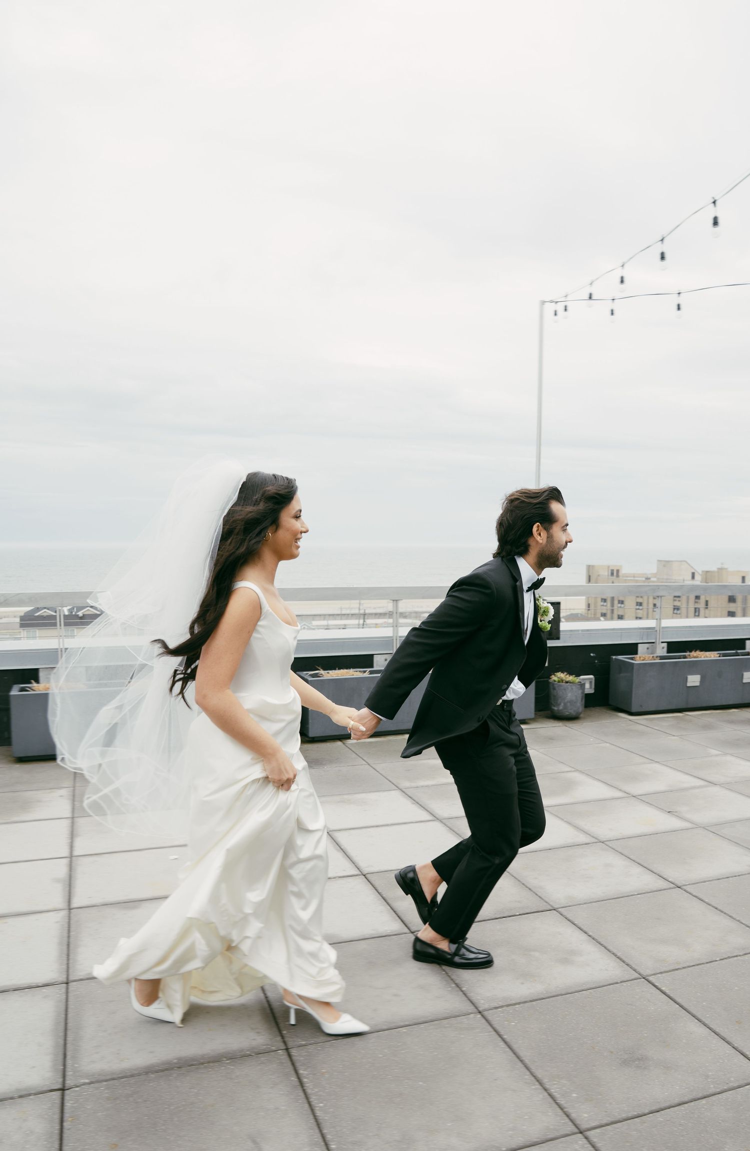 A playful moment captured on a rooftop with scenic ocean views.