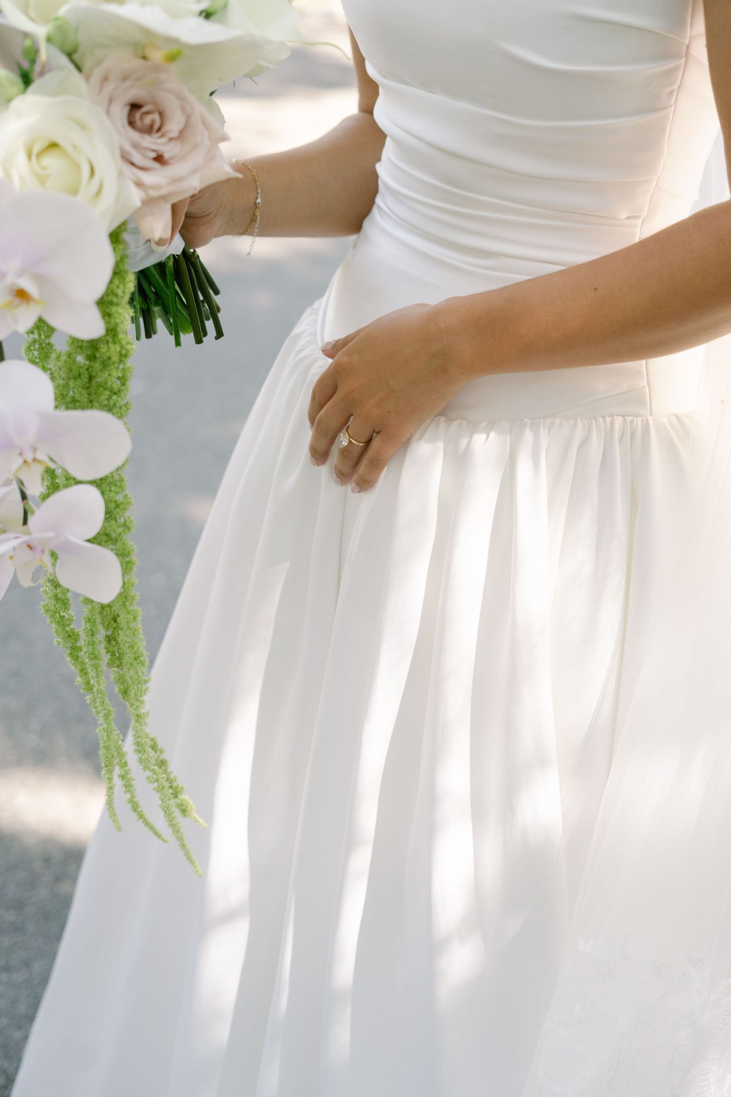 Close-up details of white wedding dresses with delicate floral bouquets.