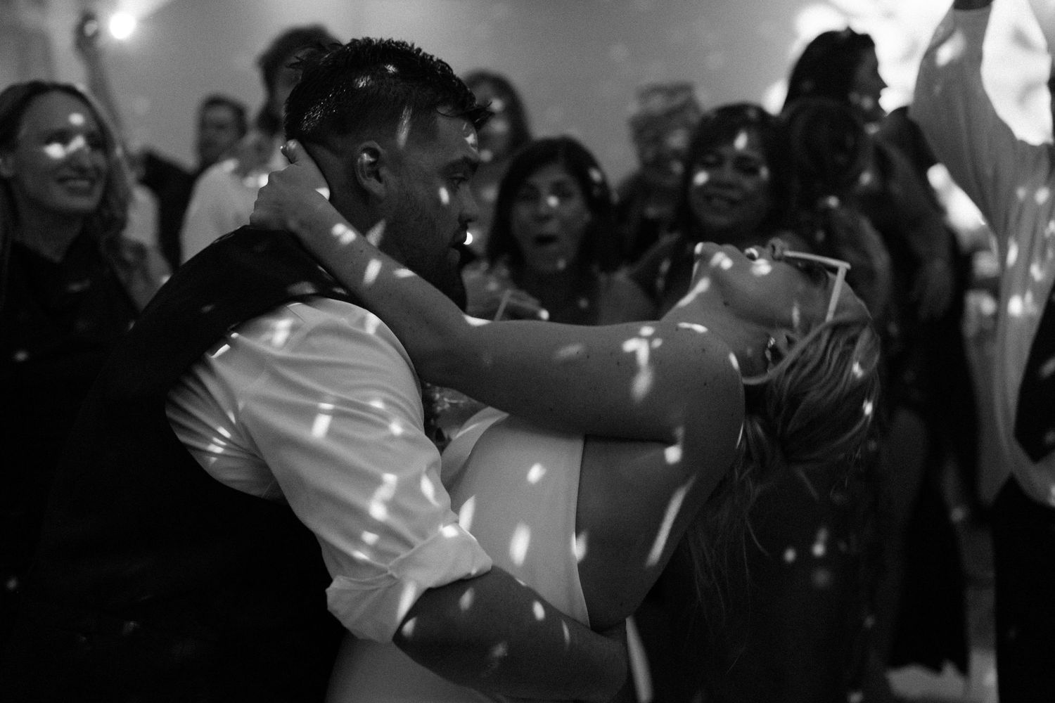 A romantic dance moment under sparkling disco lights at a wedding reception.