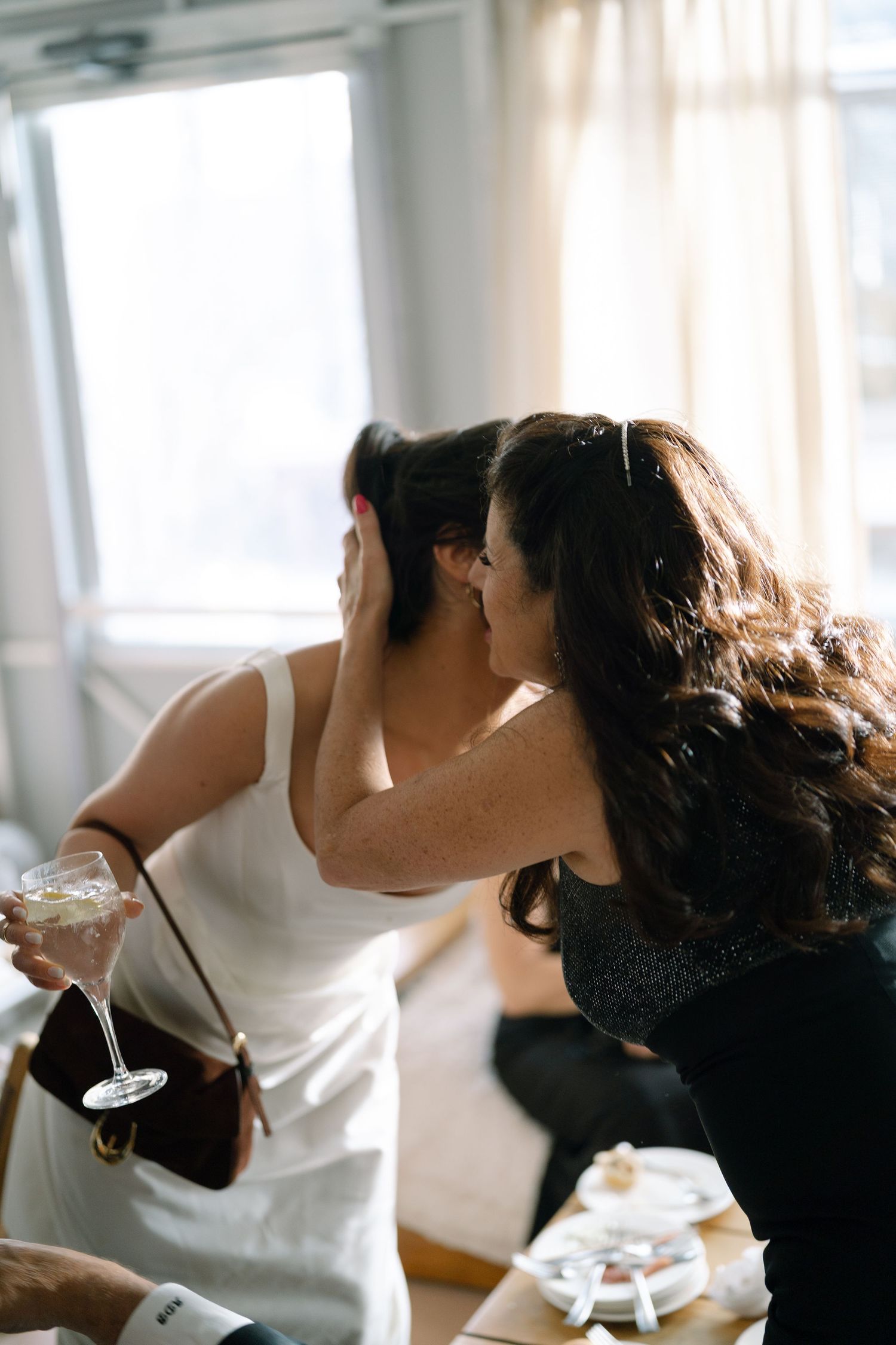 Guests toast with wine glasses during an intimate indoor celebration.