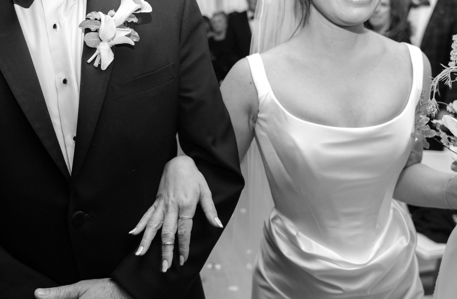 Black and white wedding photo showing formal attire details and elegant poses.