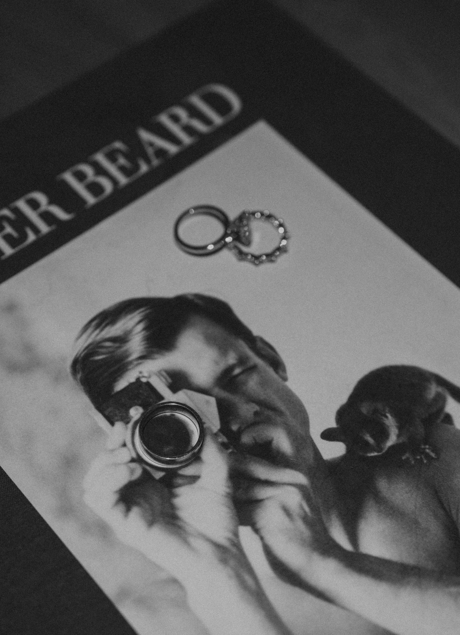 Black and white wedding ring detail photo showing two bands against a blurred backdrop.