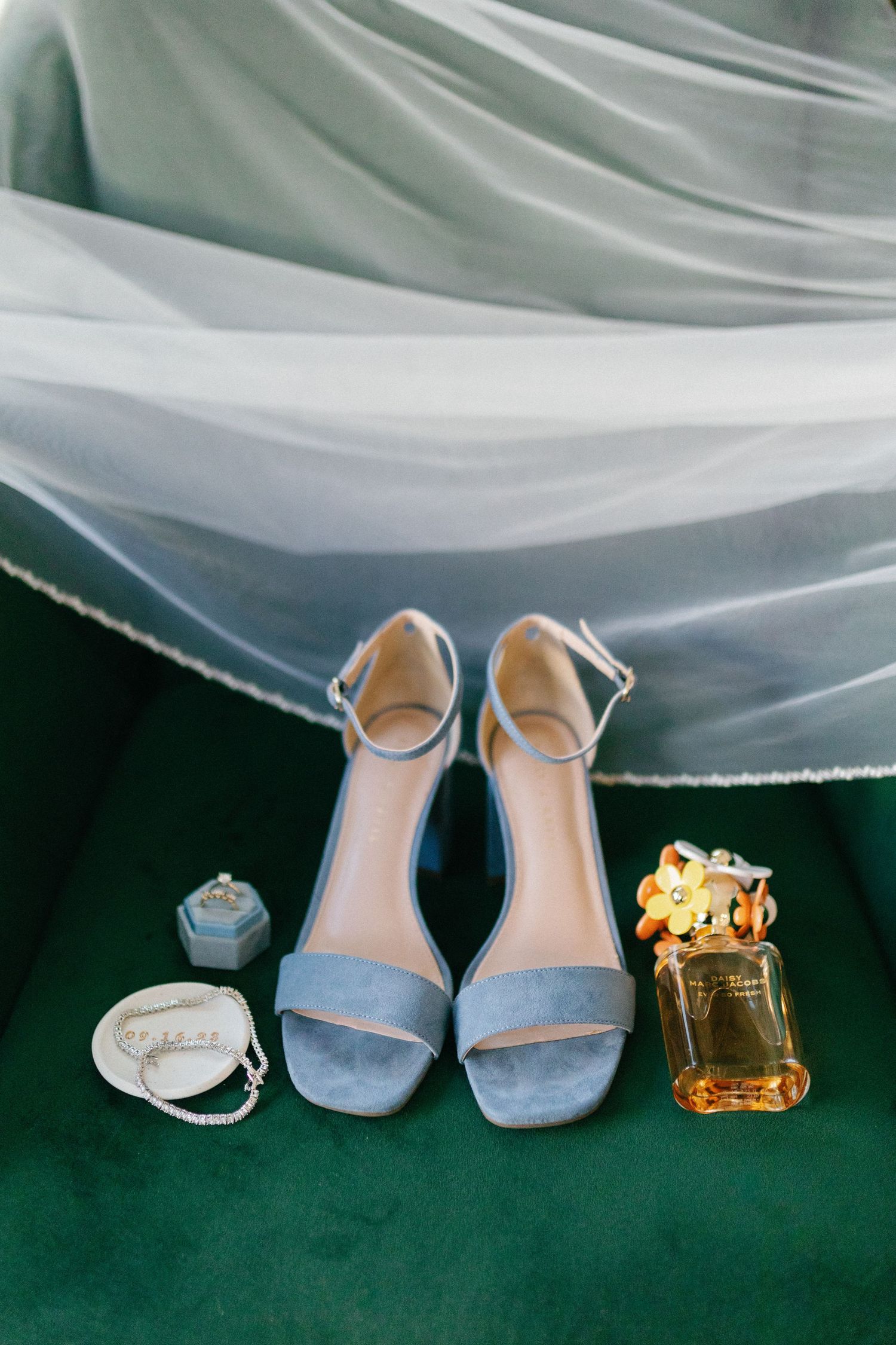 details of bride's shoes and perfume and veil