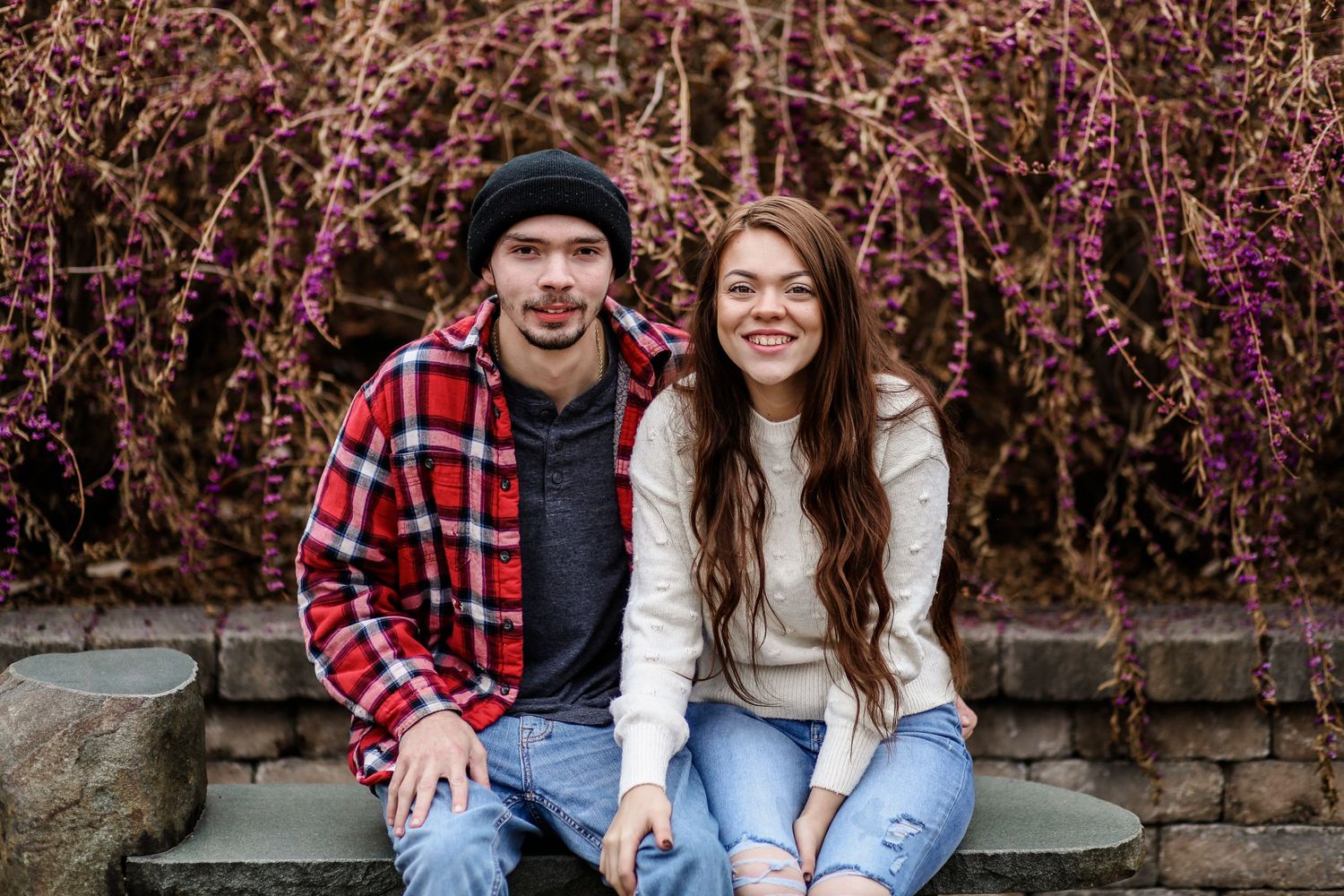 Casual portrait in front of blooming purple flower bushes.