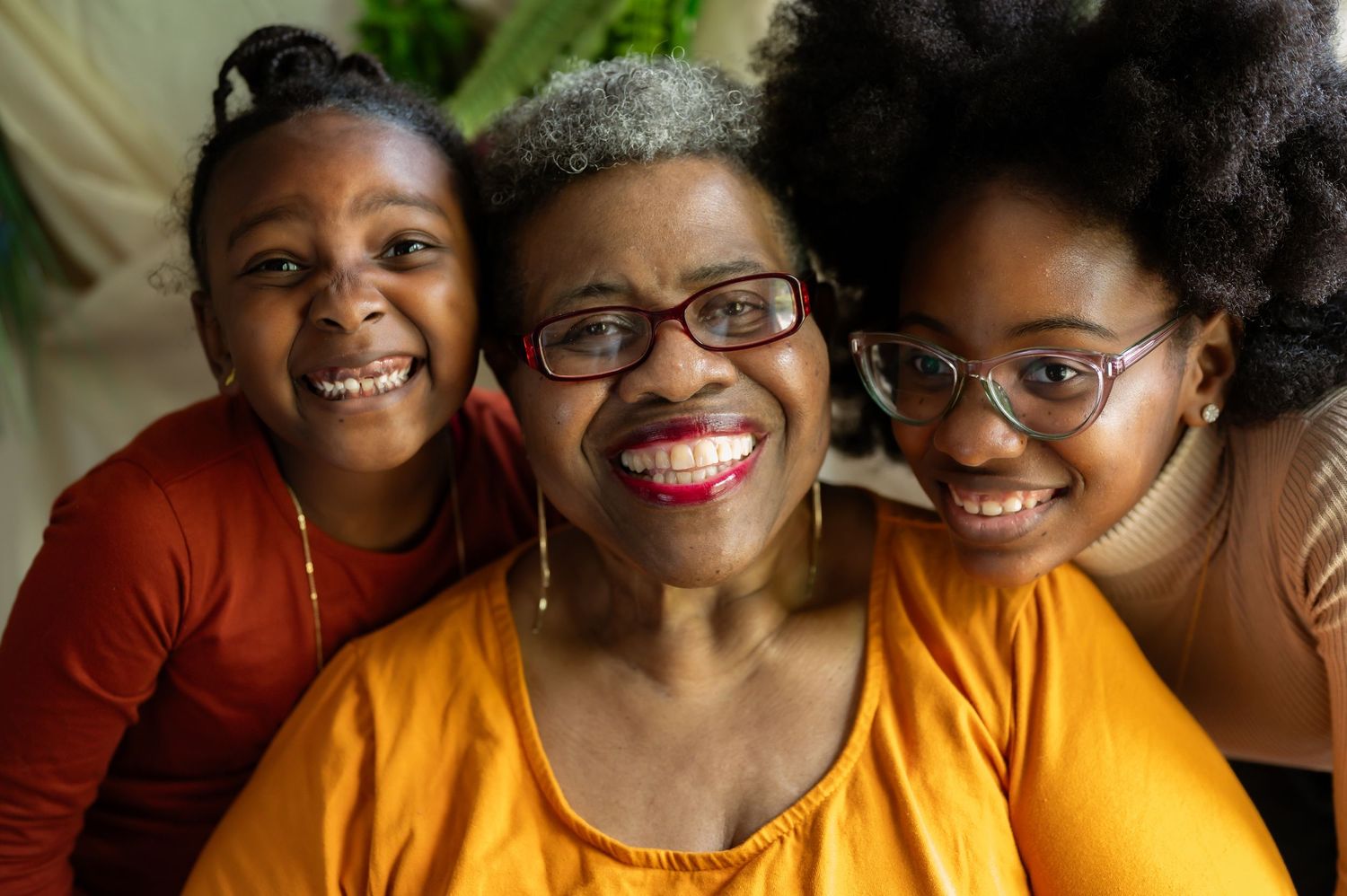 A group of people wearing yellow and orange tops smile warmly at the camera.