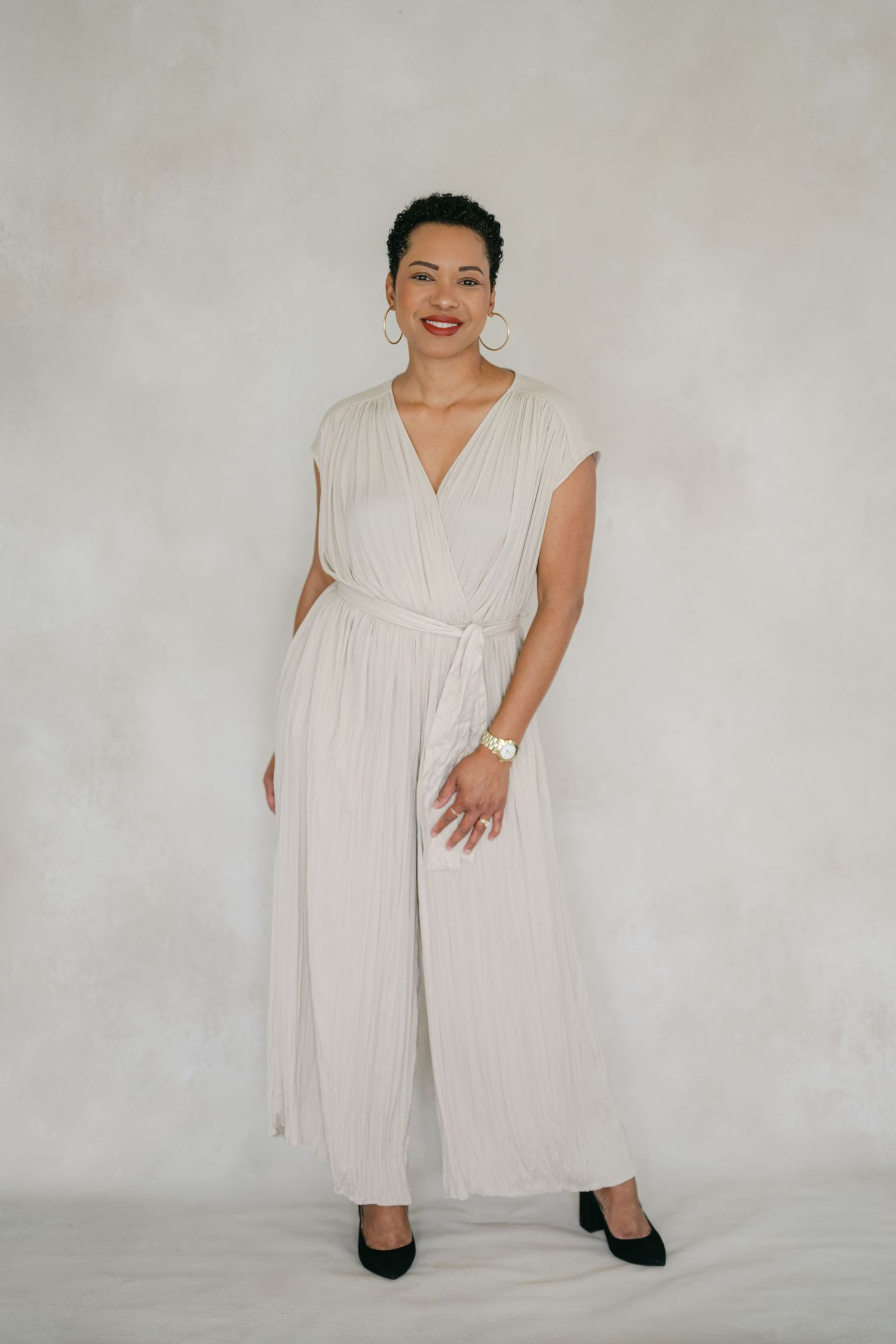 A figure wearing a flowy white wrap dress and black boots poses against a light background in various dynamic stances.