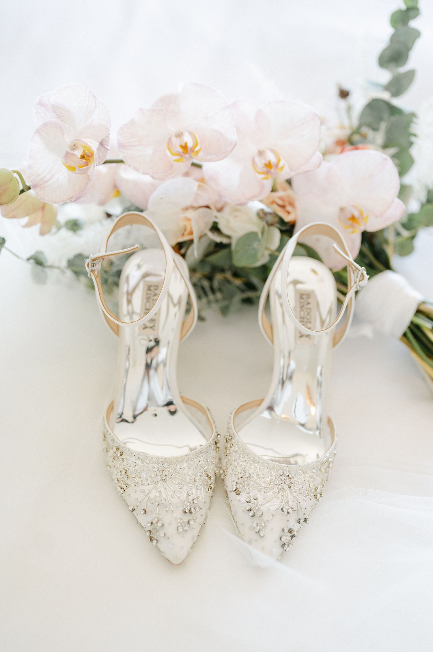 Crystal-embellished bridal heels styled with white orchids and eucalyptus sprigs. - Mae District Chicago Wedding