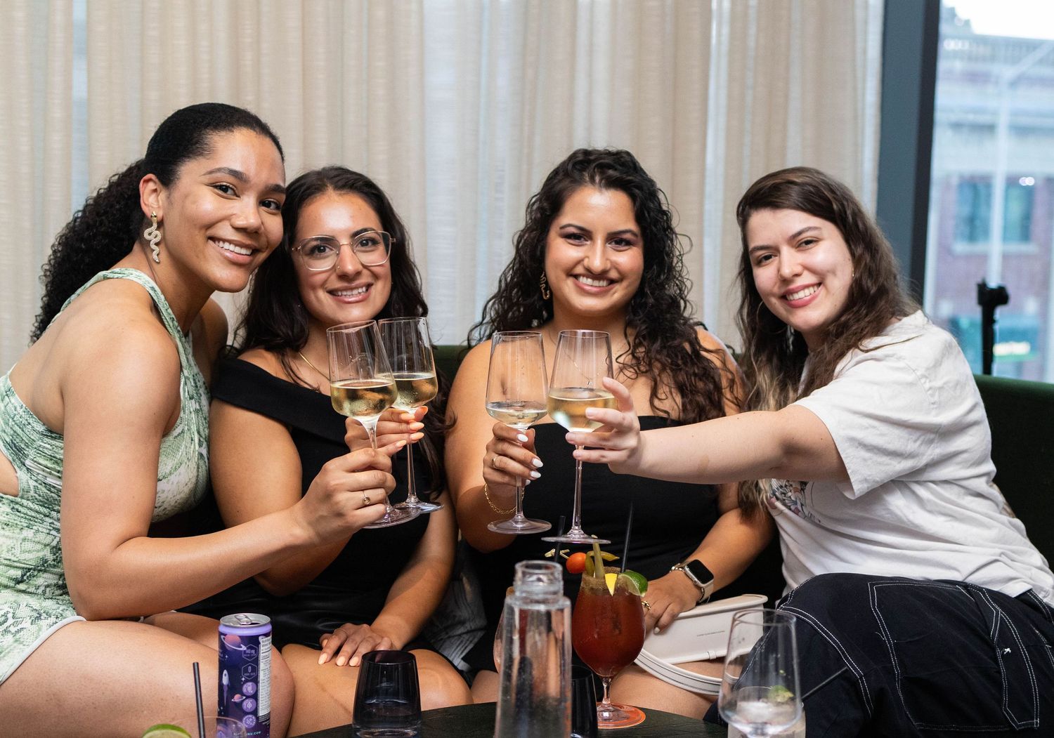 Group of friends raising glasses in toast at social gathering.