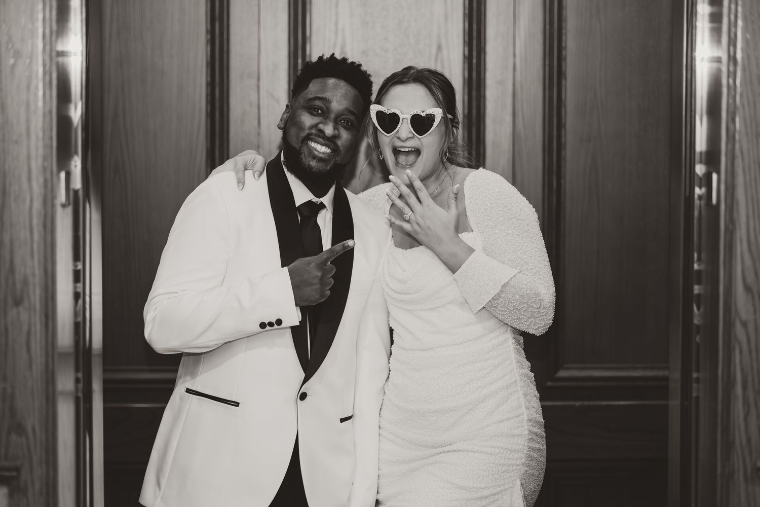 Black and white photos show a couple wearing formal attire and sunglasses smiling and embracing in a studio setting.