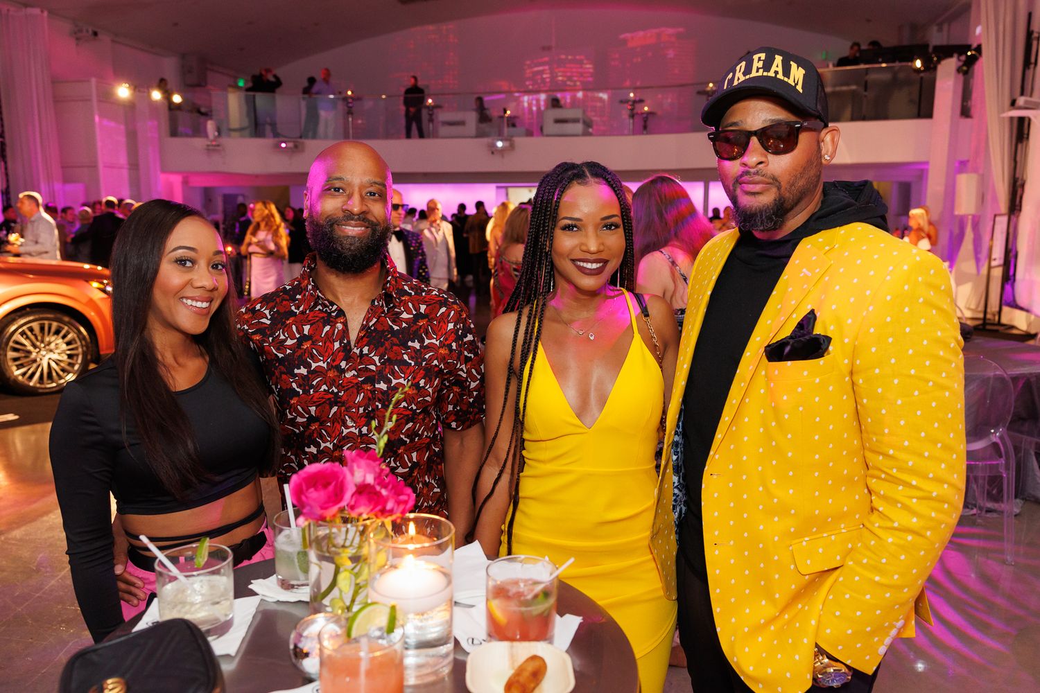 A group enjoying dinner together at a trendy restaurant with pink lighting and elegant table settings for an Event Photography in Miami