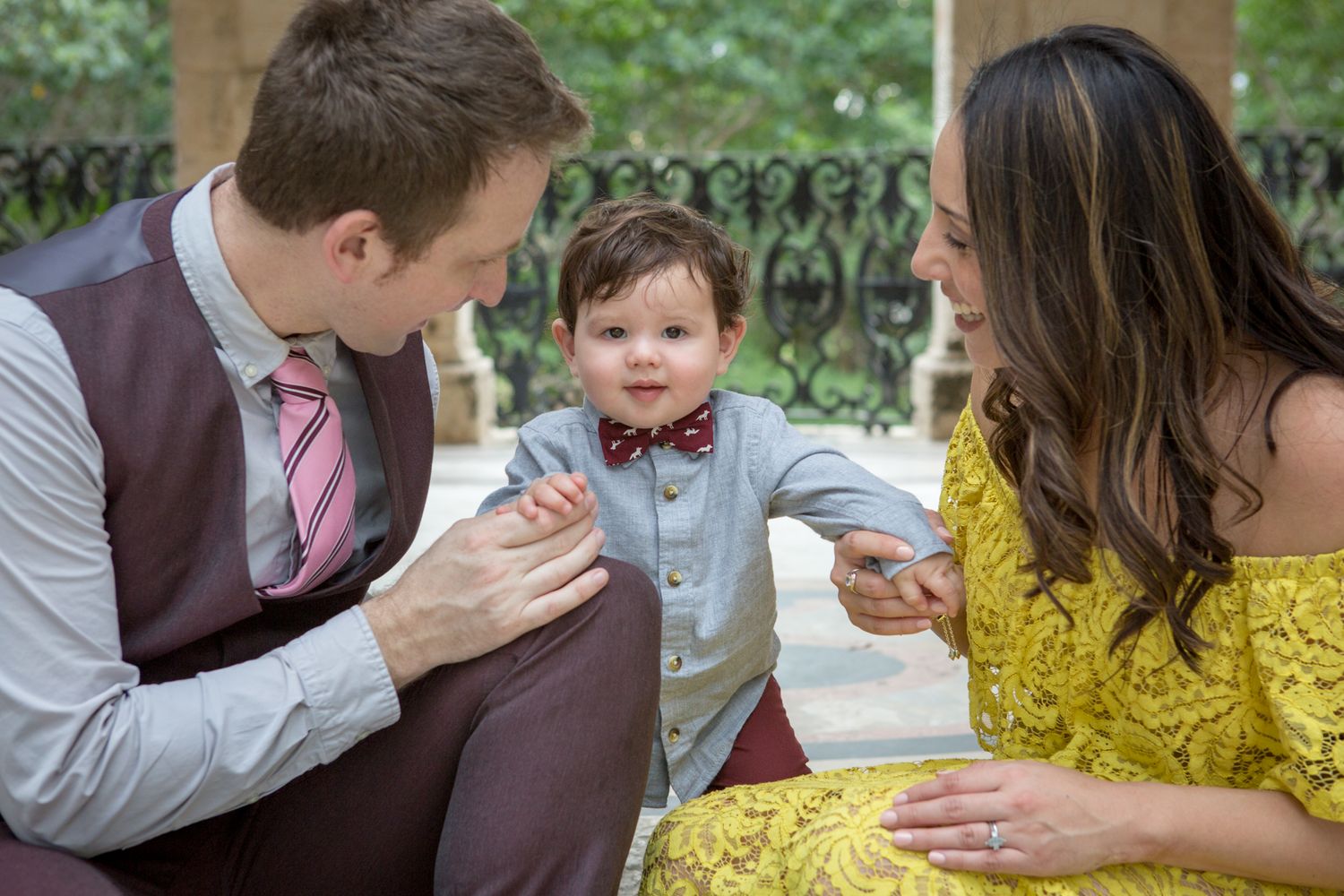 A candid family moment captured outdoors with parents interacting with their young child in a miami lifestyle family photos shoot