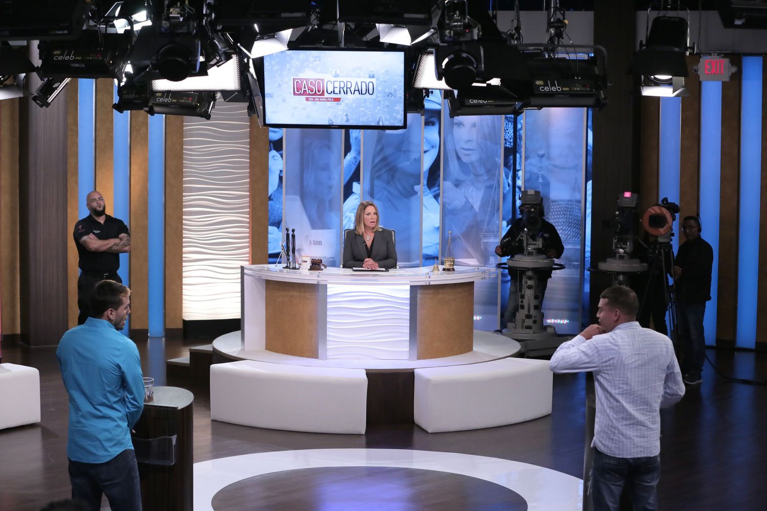 Wide shot of television studio with blue backdrop and production equipment in a behind the scenes set photography session in miami