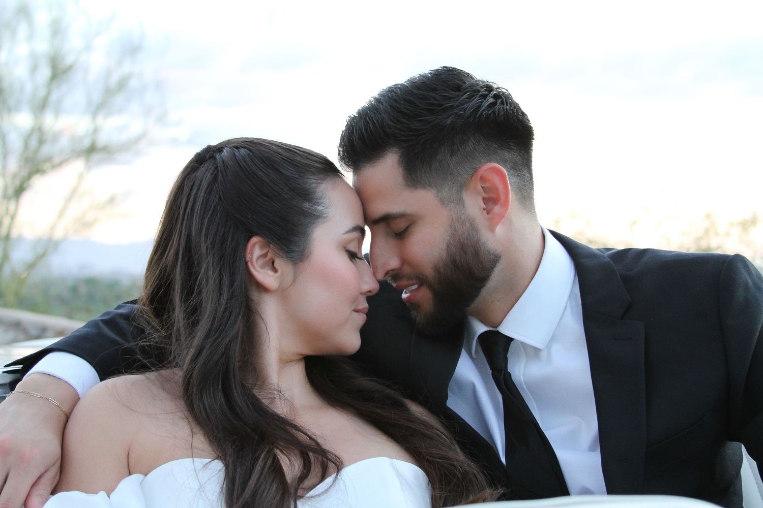 Romantic moment between couple in wedding attire during sunset.