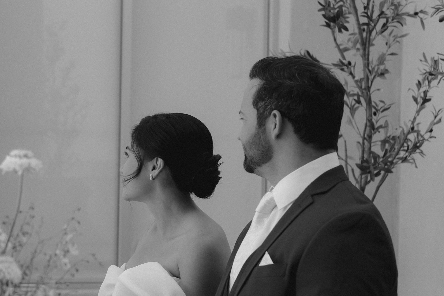 Elegant black and white profile portrait of newlyweds in formal attire.