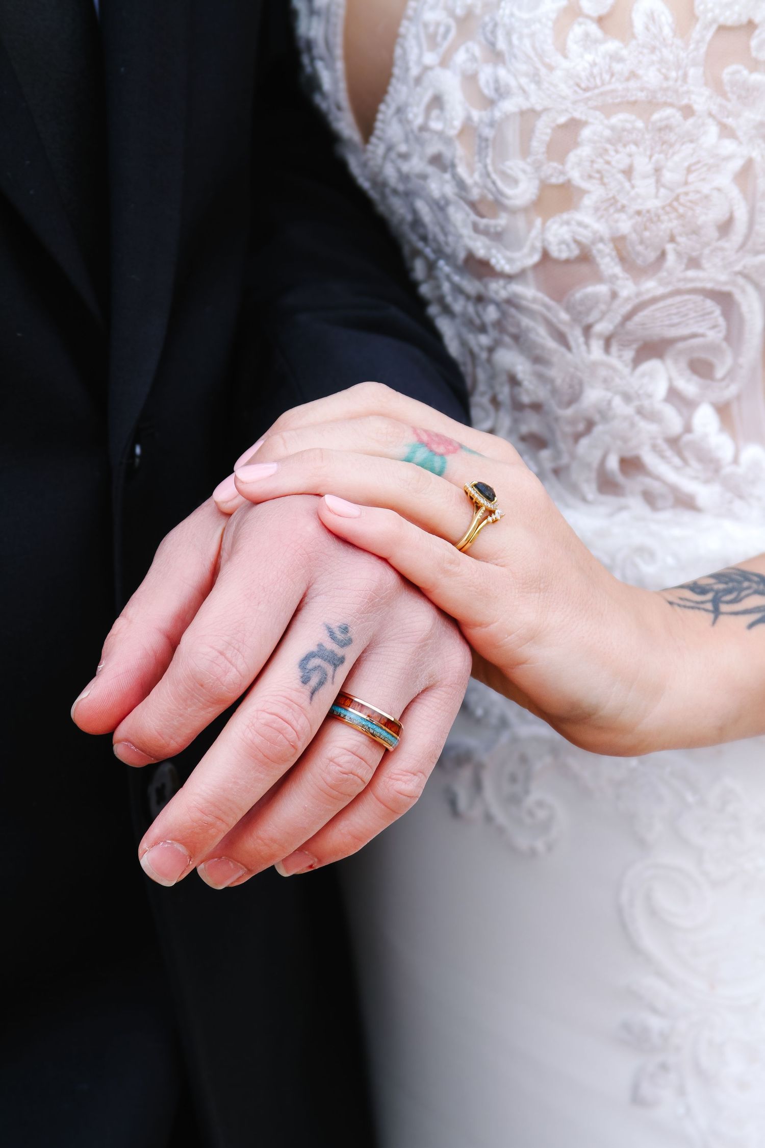 Close-up shots of hands wearing wedding rings and showing intricate tattoo details.