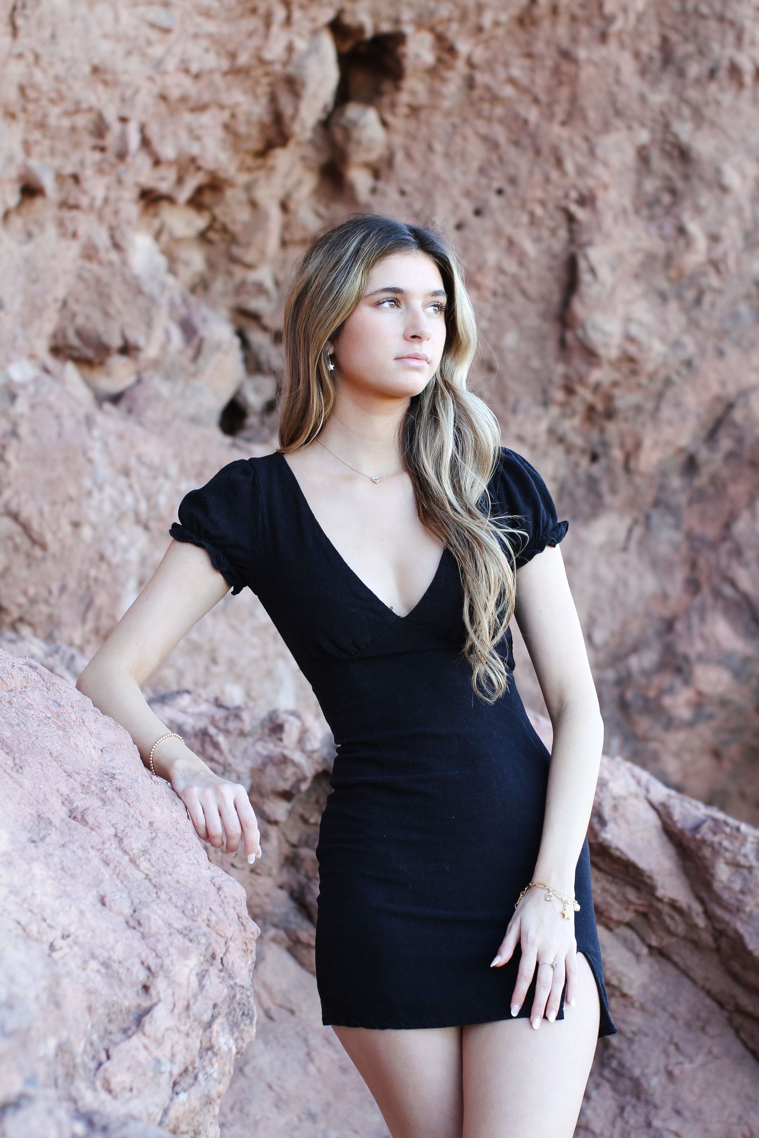Fashion portrait featuring a black mini dress against desert rock formations.