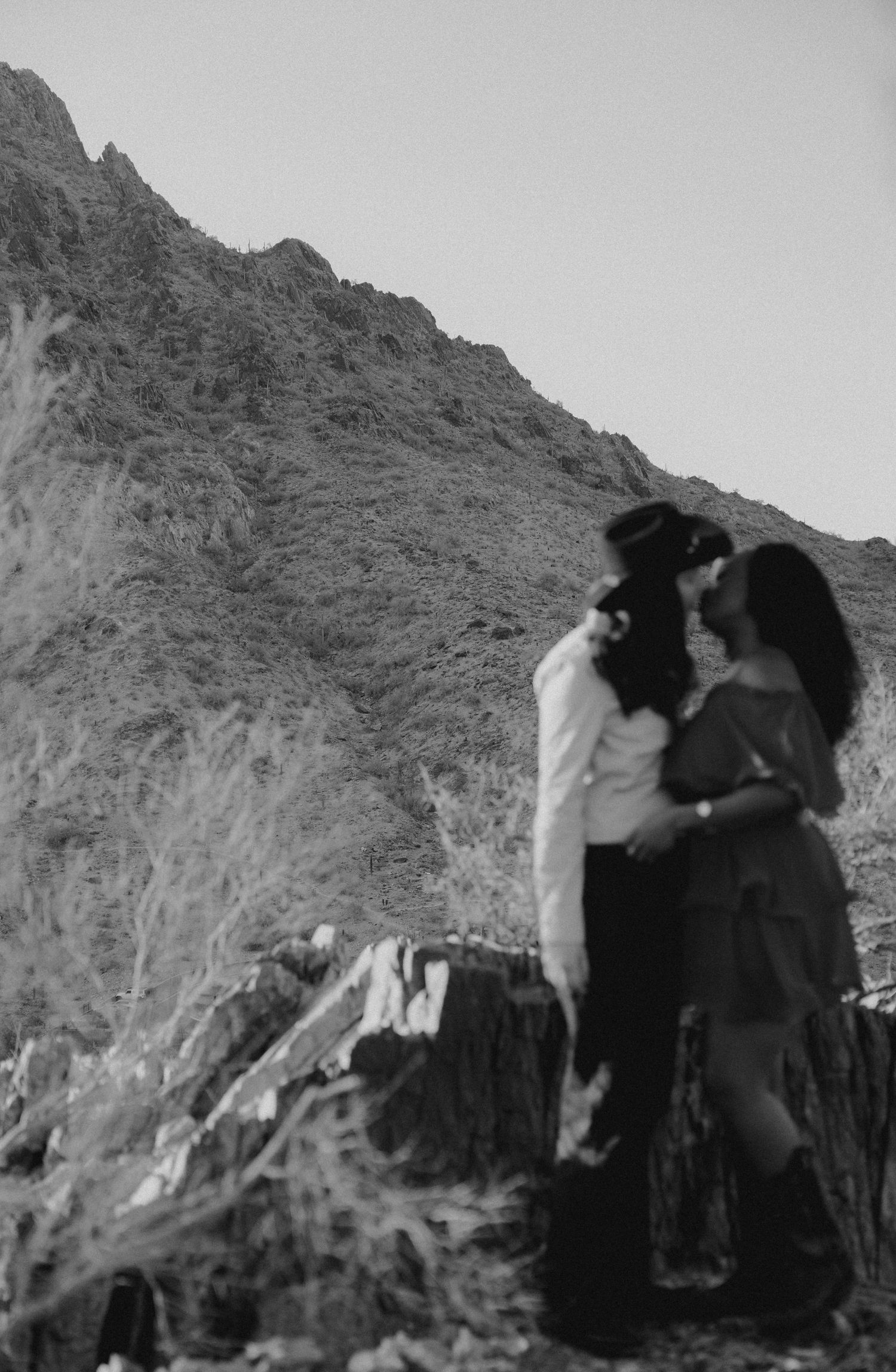 Black and white wedding portrait with dramatic mountain backdrop.