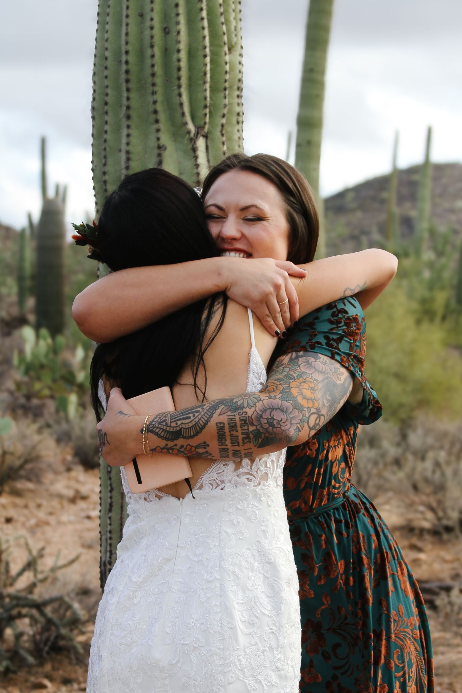 Wedding photos capturing heartfelt hugs against a desert backdrop with cacti.
