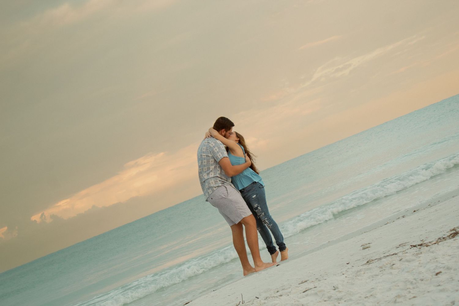 A portrait of a husband and wife kissing at sunset