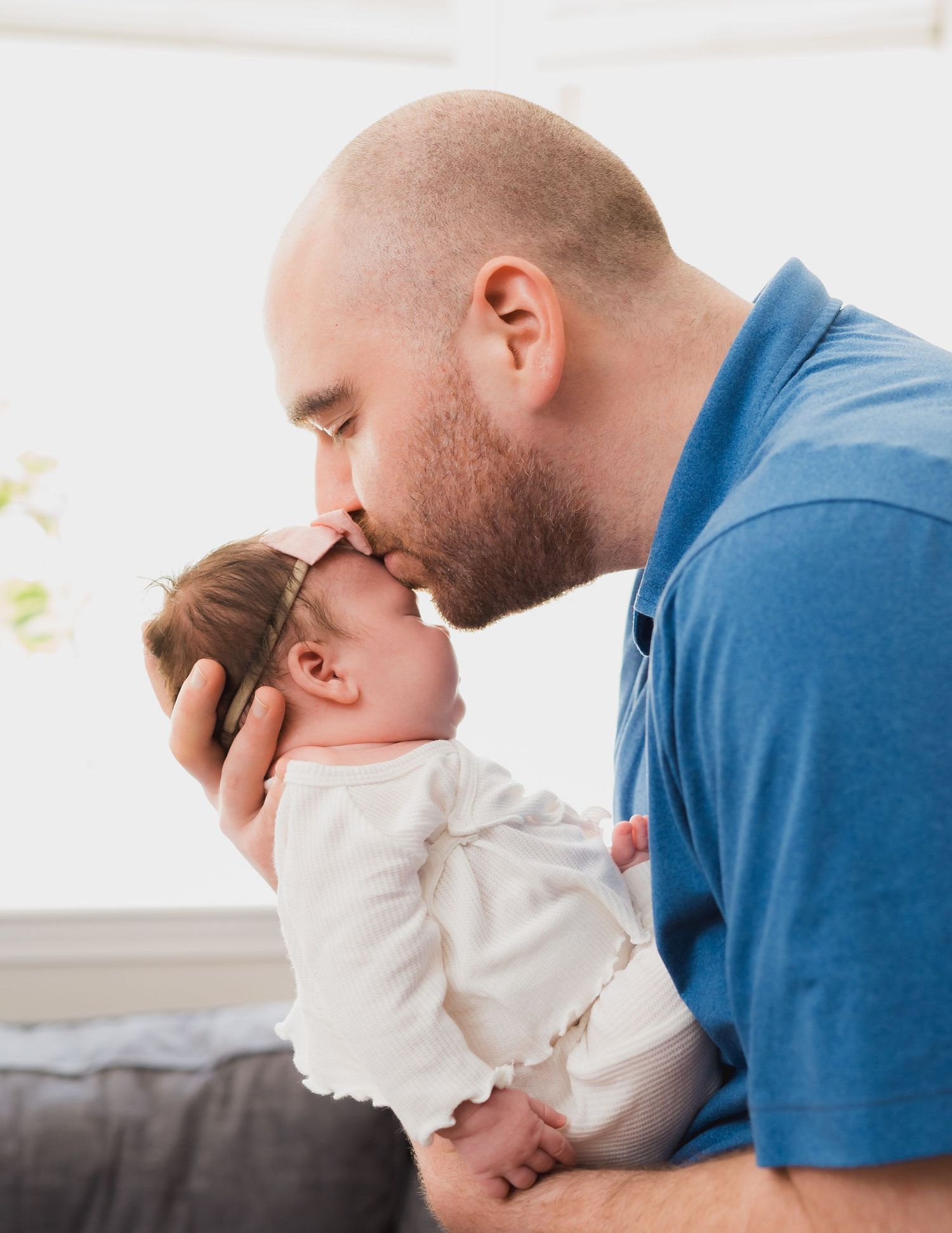 Dad is kissing baby on her forehead