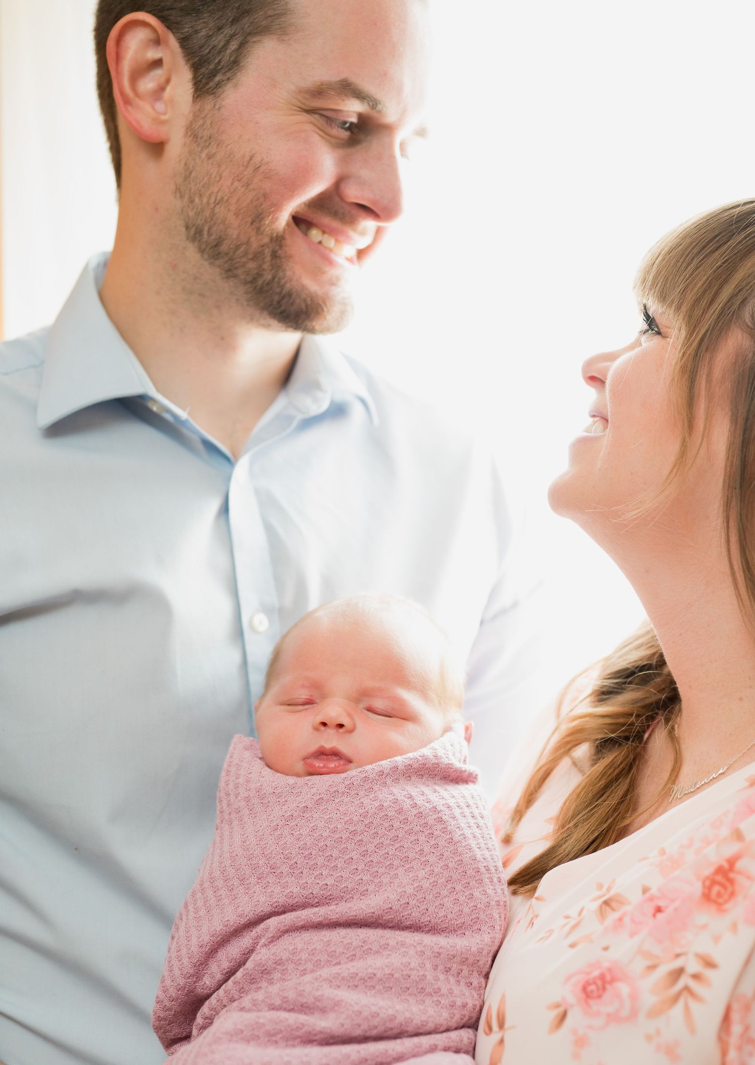 Mom and dad are holding baby