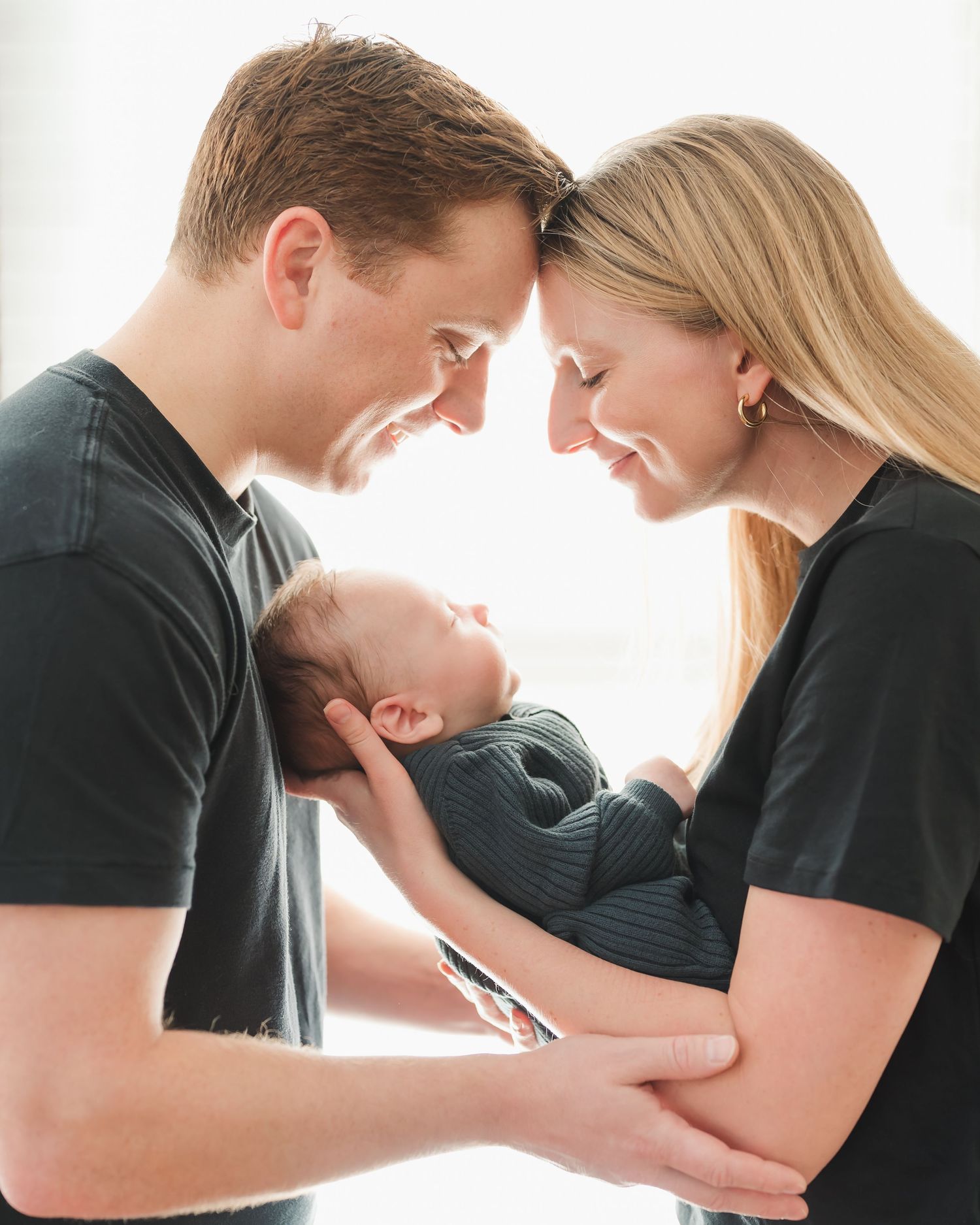 mom and dad are holding baby
