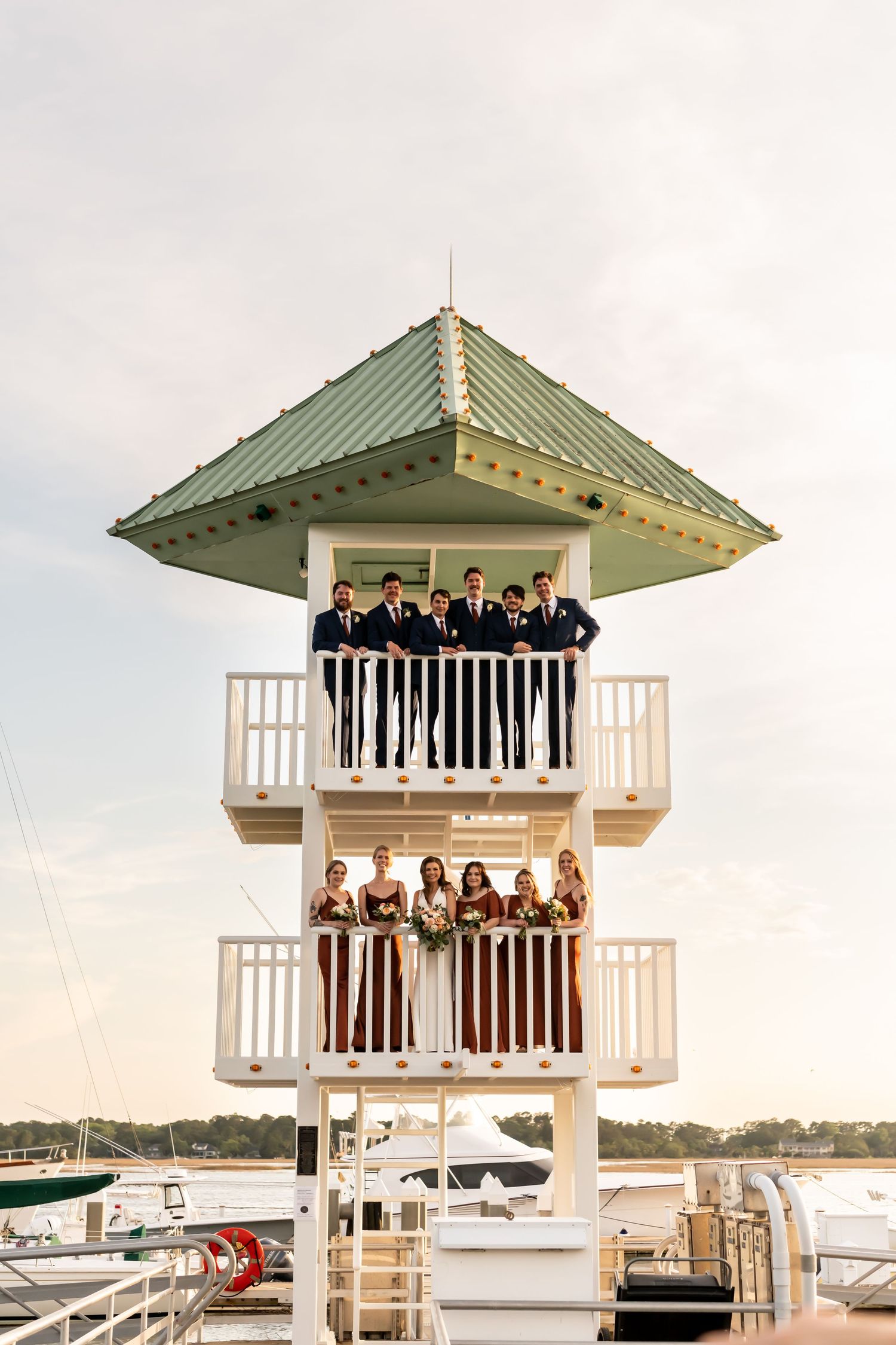 Two-story white observation tower overlooking marina with wedding party.