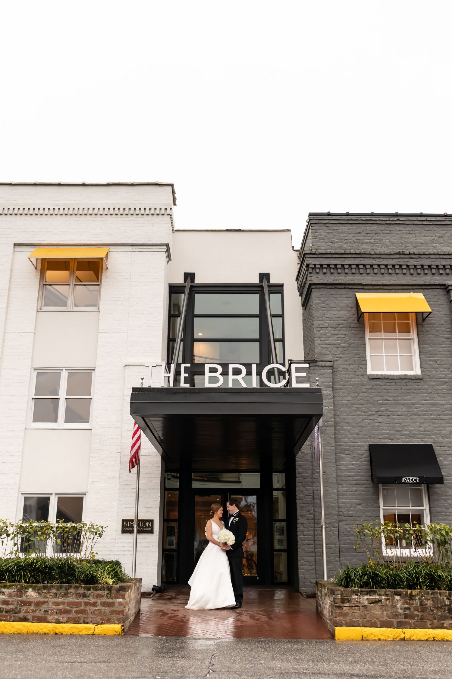 Bride and Groom in front of The Brice hotel entrance with black and white brick exterior.