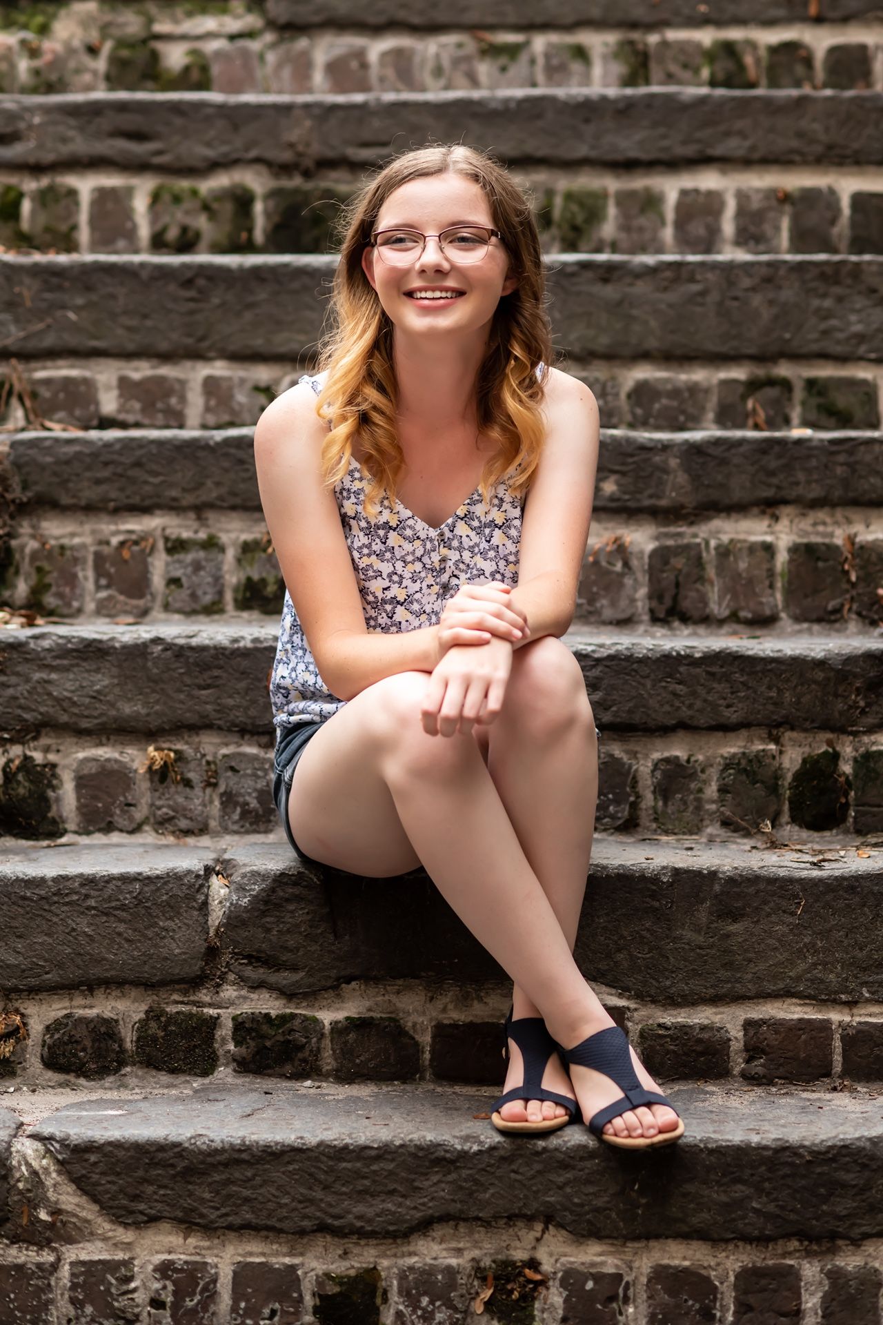 A series of candid portraits showing someone sitting on brick steps with an amused expression.