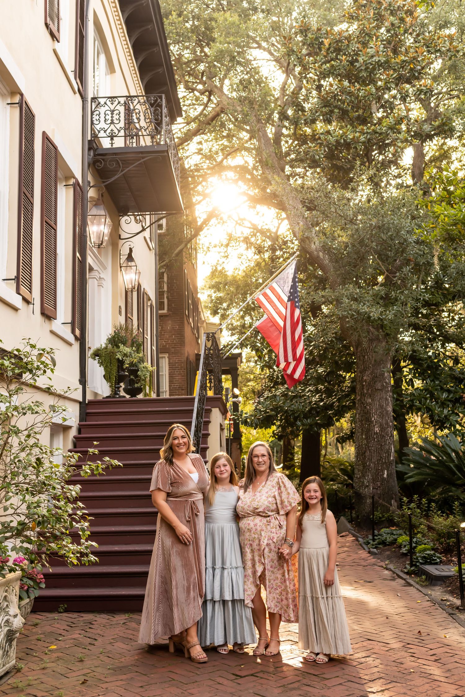 Historic house steps with American flag at sunset in a charming southern setting.